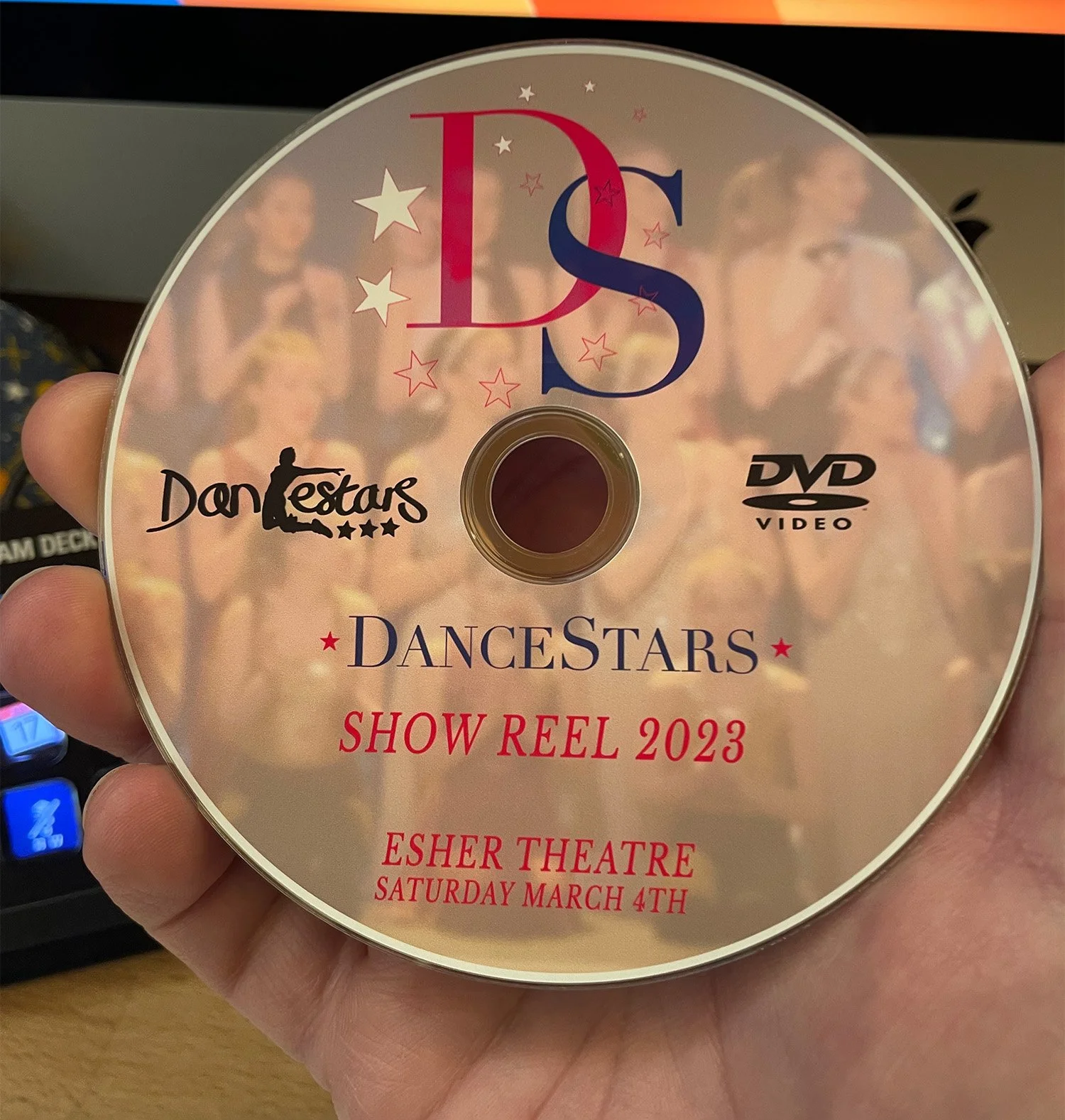A DVD titled 'DanceStars Show Reel 2023' with a blurred background of dancing performers, held in a person's hand.
