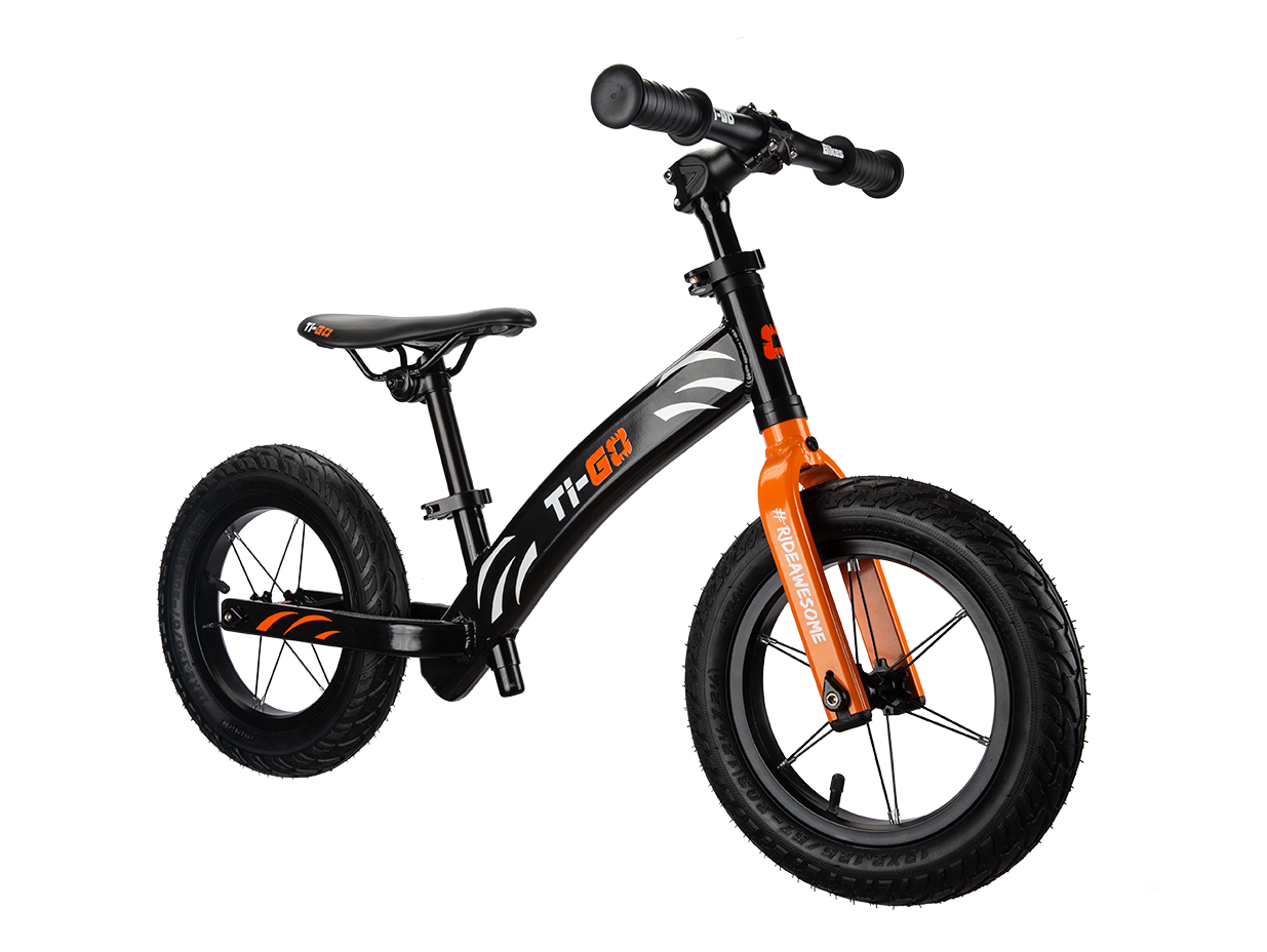 Black and orange kids' balance bike with thick tires, handlebars, and a sleek design.