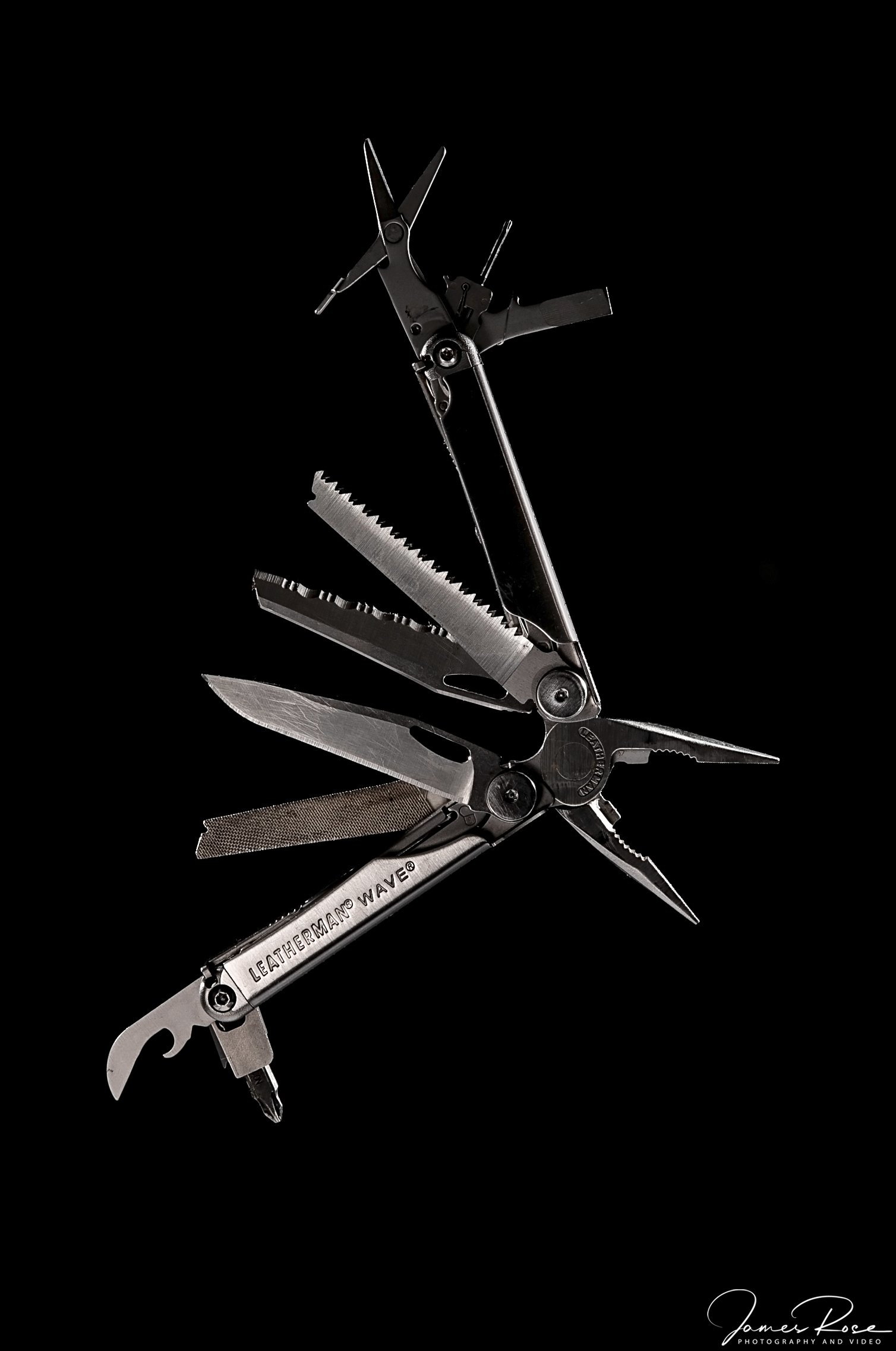 Close-up of a multifunctional pocket knife with various tools extended, including a saw, a corkscrew, a flat screwdriver, and a bottle opener, against a black background.