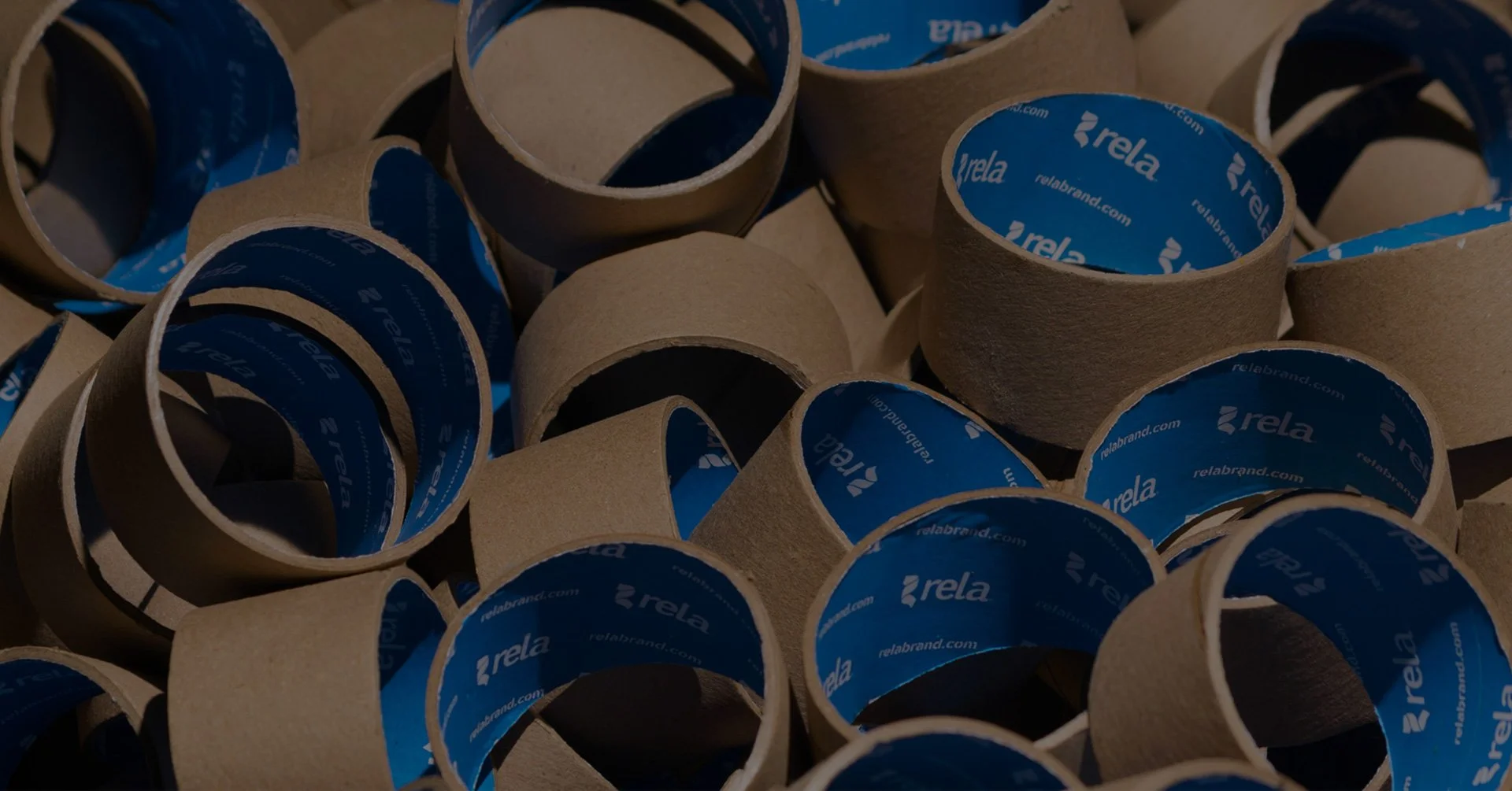 Numerous empty cardboard rolls with blue inner linings branded 'rela'.