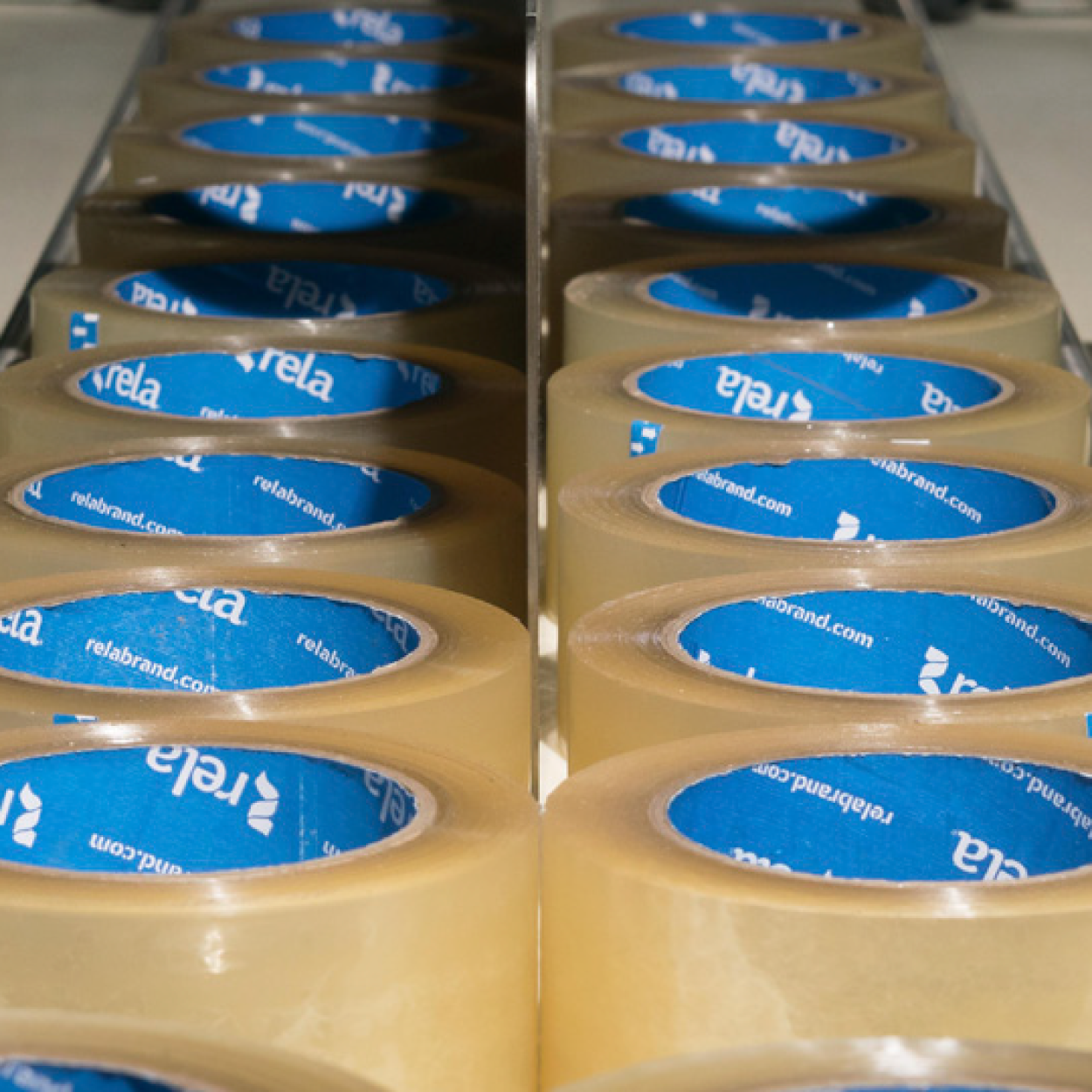 Rows of beige adhesive tapes with blue inner paper cores displaying the relabel logo.