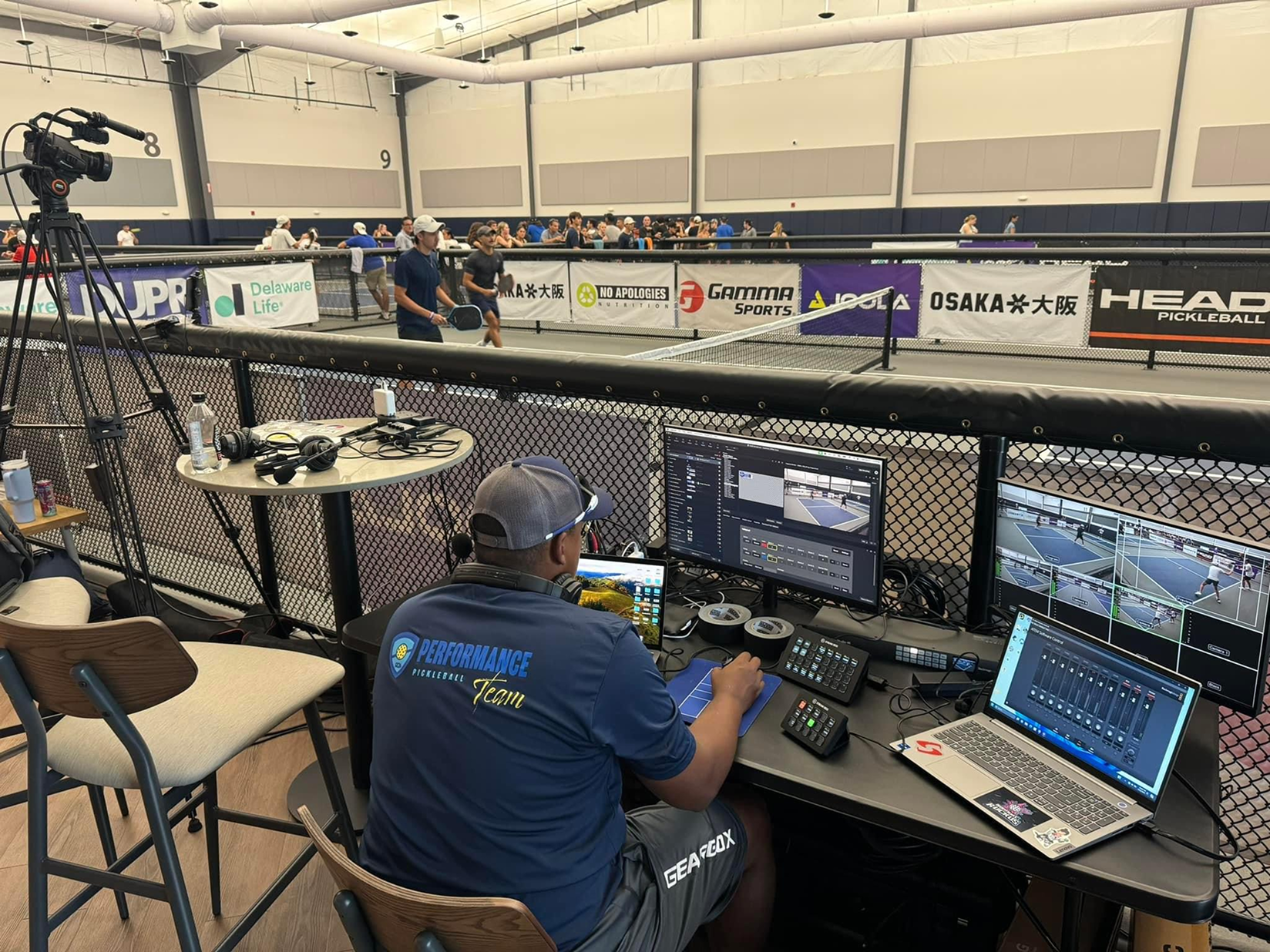Performance Productions crew member managing multi-screen live stream production courtside at a pickleball tournament