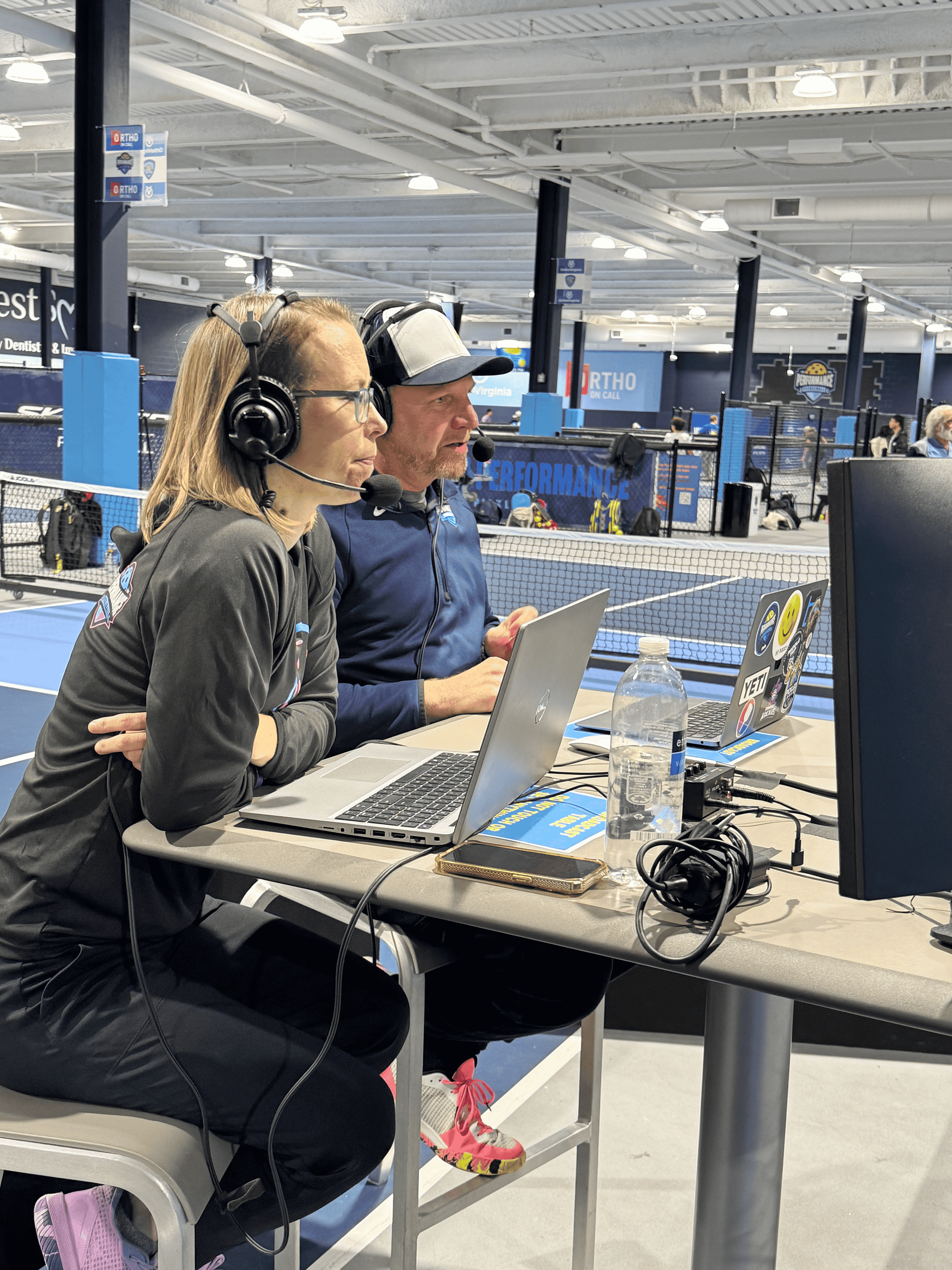 Two commentators with headsets calling a live pickleball tournament for Performance Productions