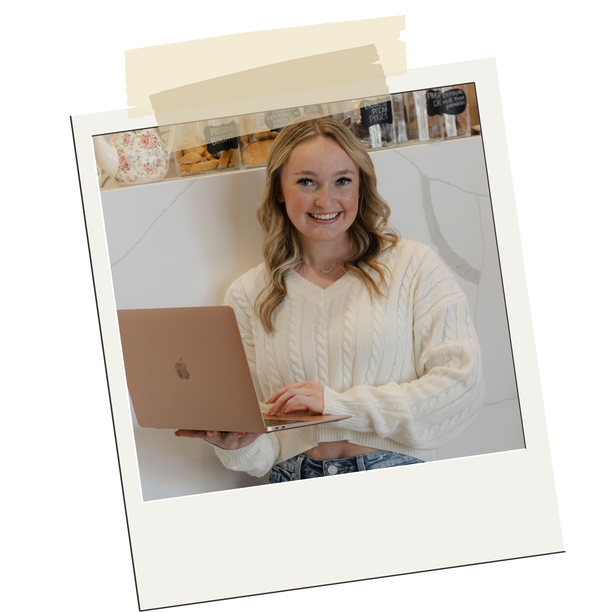Nevaeh owner of Digital Heaven smiling while sitting with a laptop in front of her in a cafe.