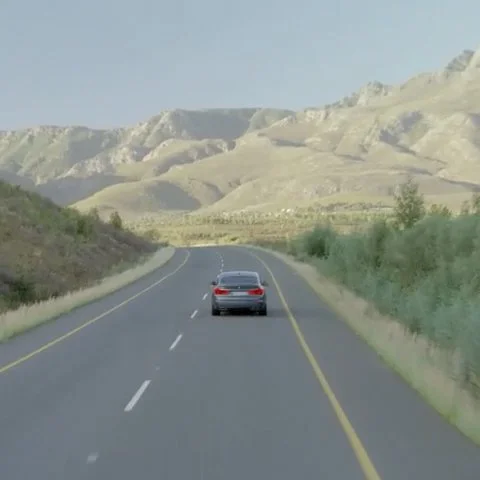 Car driving on open road through mountains