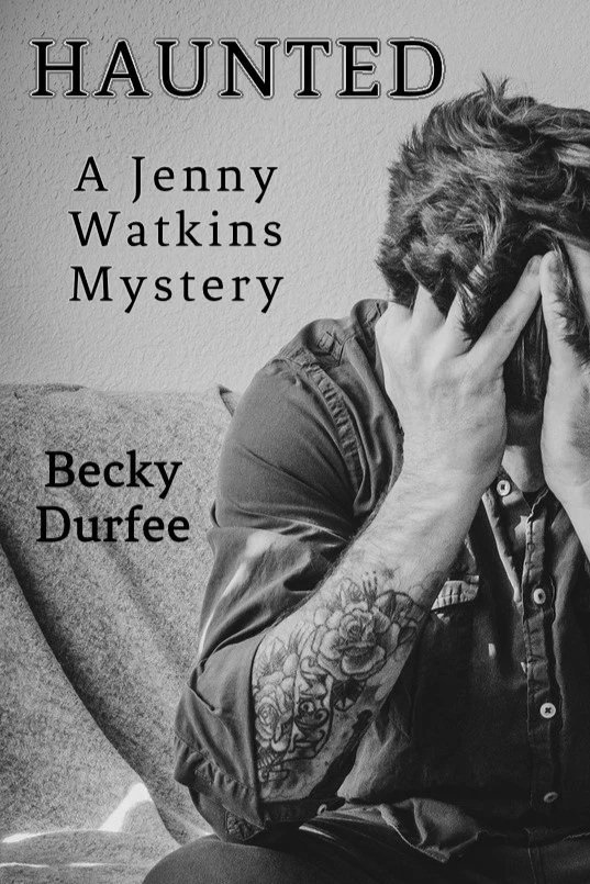 Haunted book cover black and white photo showing a tattooed man holding his head in his hands.