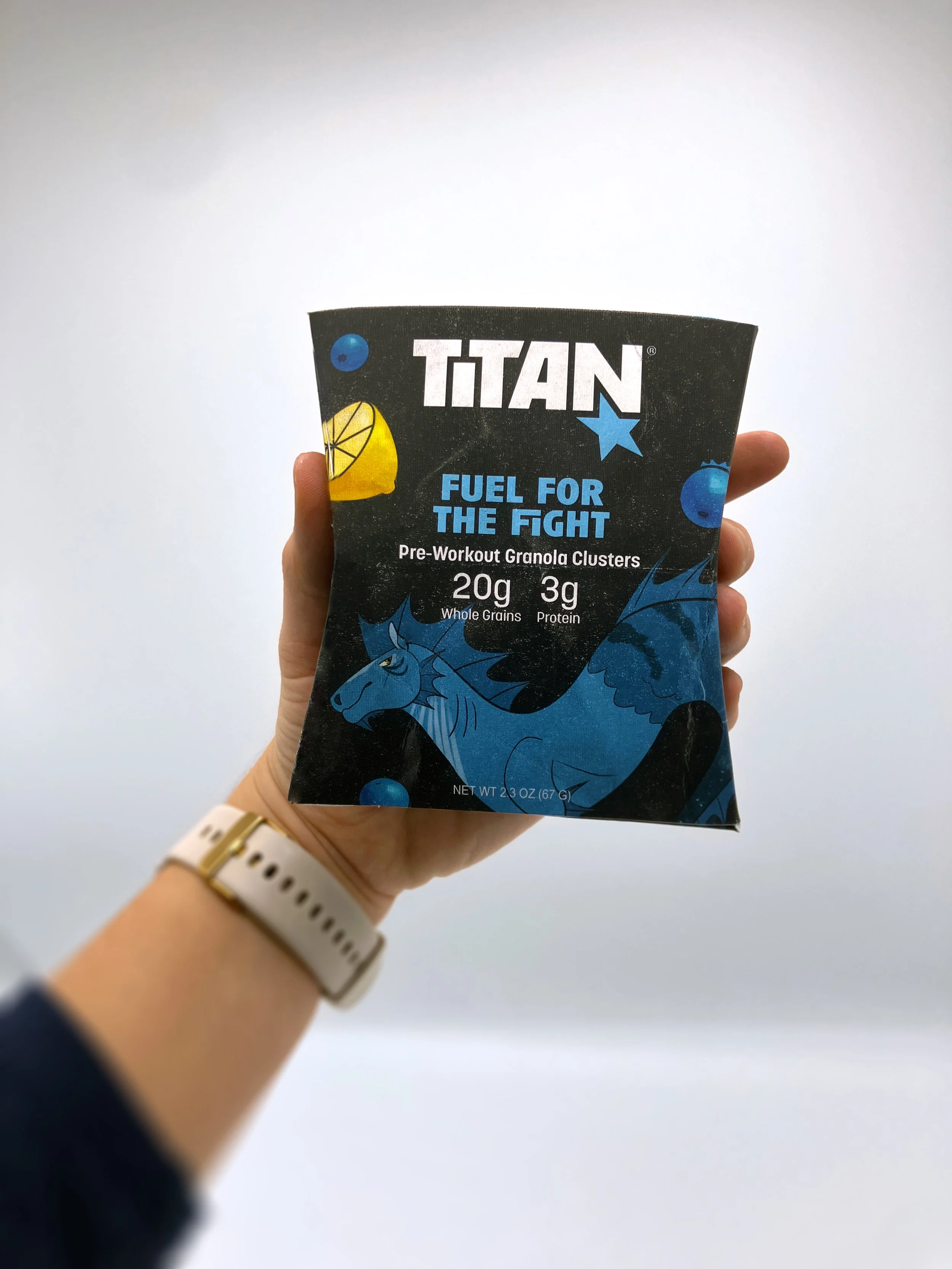 Hand holding front view of hippocamp, pre-workout granola packaging.
