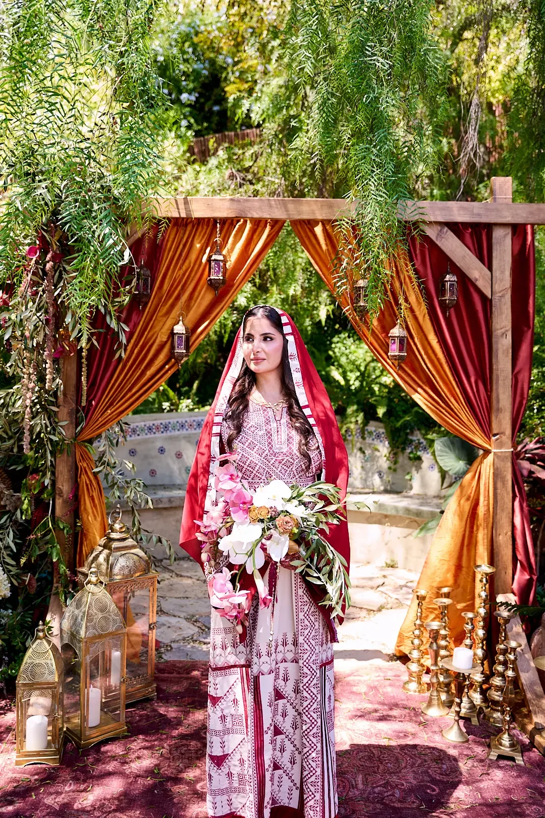 Traditional bride holding her bouquet in front of a beautifully styled wedding altar.