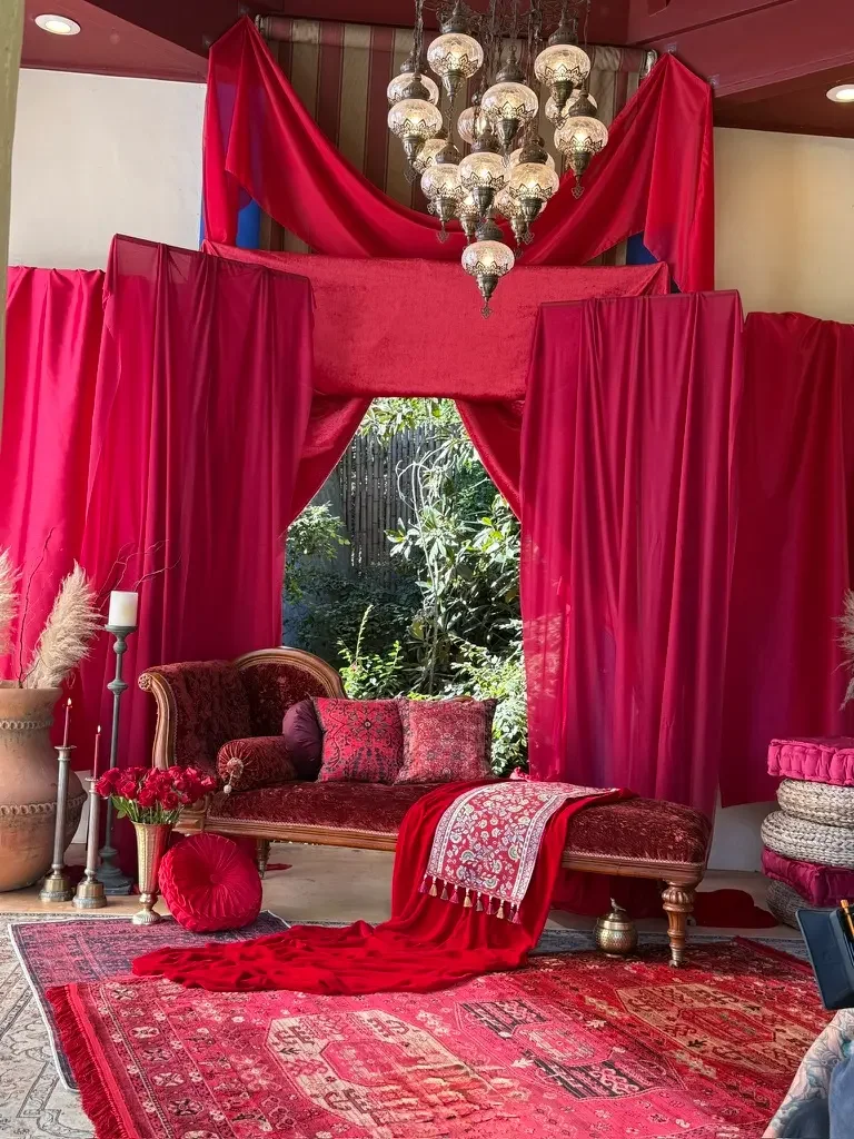 Moroccan-inspired interior styled with red drapery and lounge seating for a music video at XOHH Events in Los Angeles.