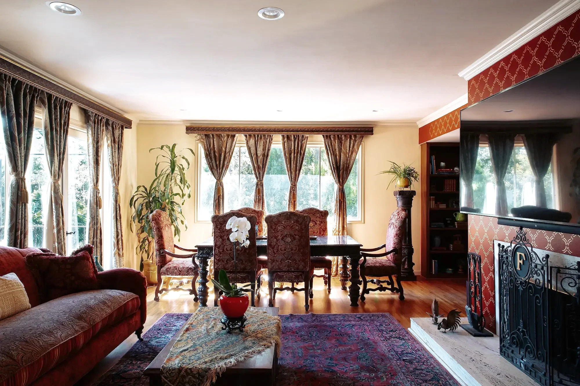 Grand Salon living and dining space with a formal dining table, television, mirrors, and richly decorated interiors.