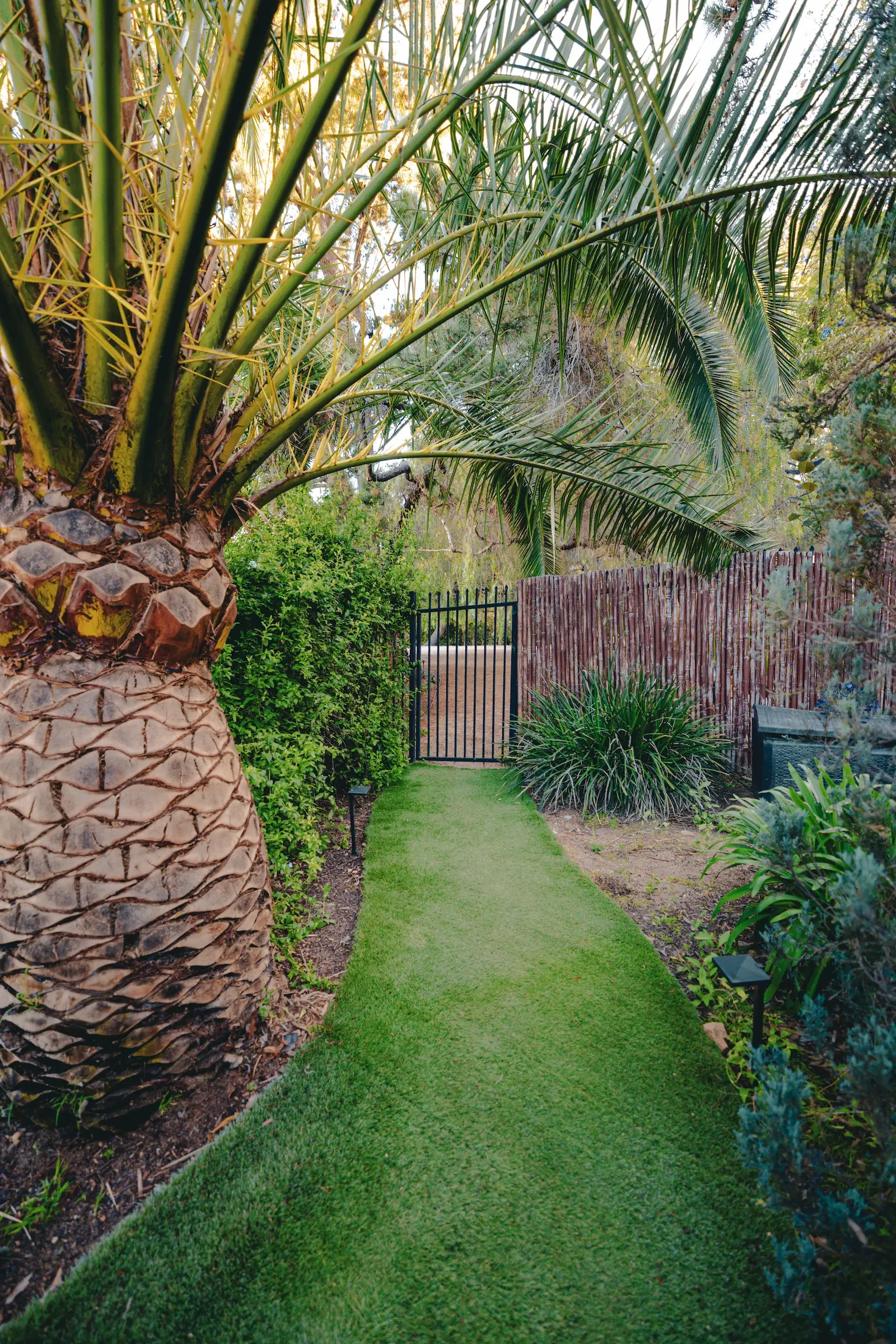 Secluded garden walkway leading from the main backyard toward Vista Grove at XOHH Events.