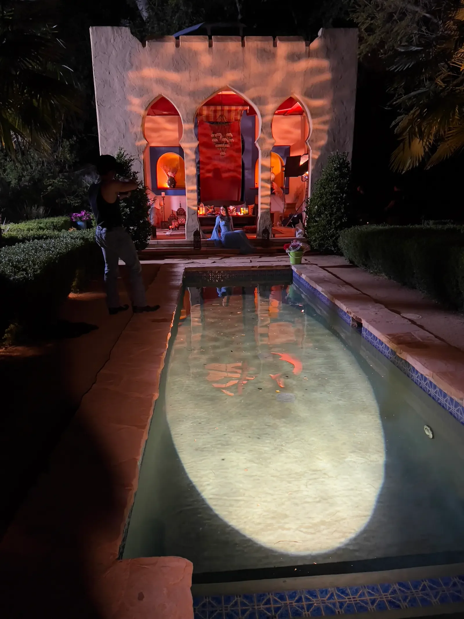 Moroccan-inspired Kasbah staged for nighttime filming at XOHH Events in the Hollywood Hills, Los Angeles, with illuminated arches and production lighting reflected in the pool.