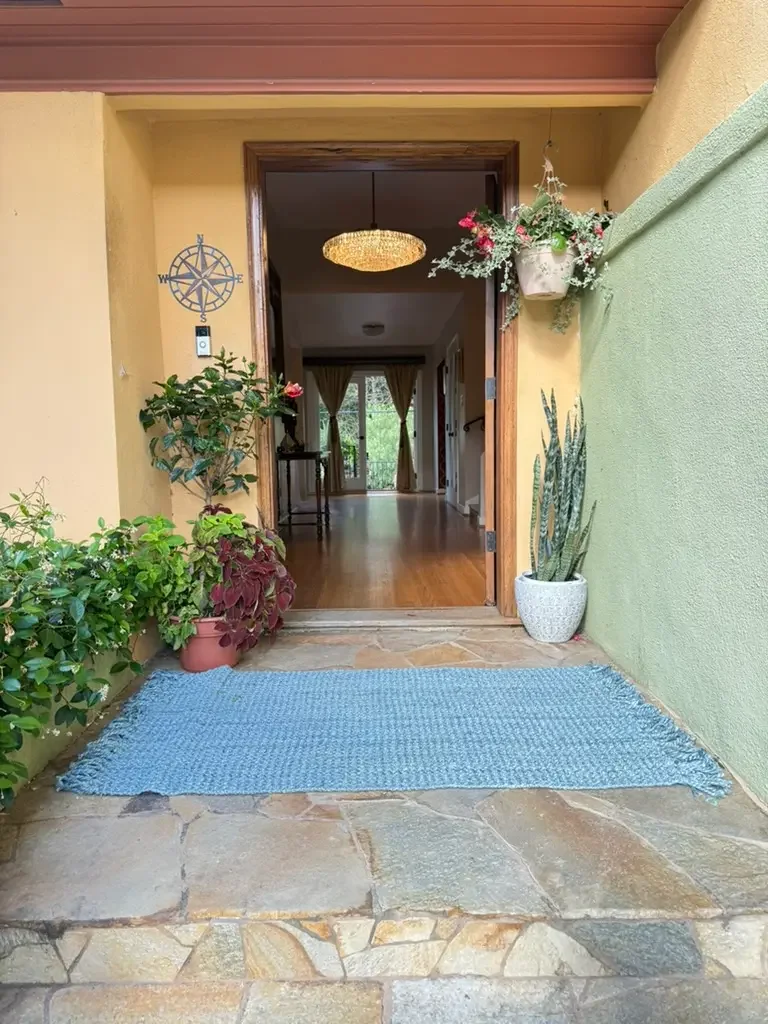 Front entrance styled with potted plants and a blue carpet to suit a production’s set design at XOHH Events, a private Hollywood Hills filming location in Los Angeles.