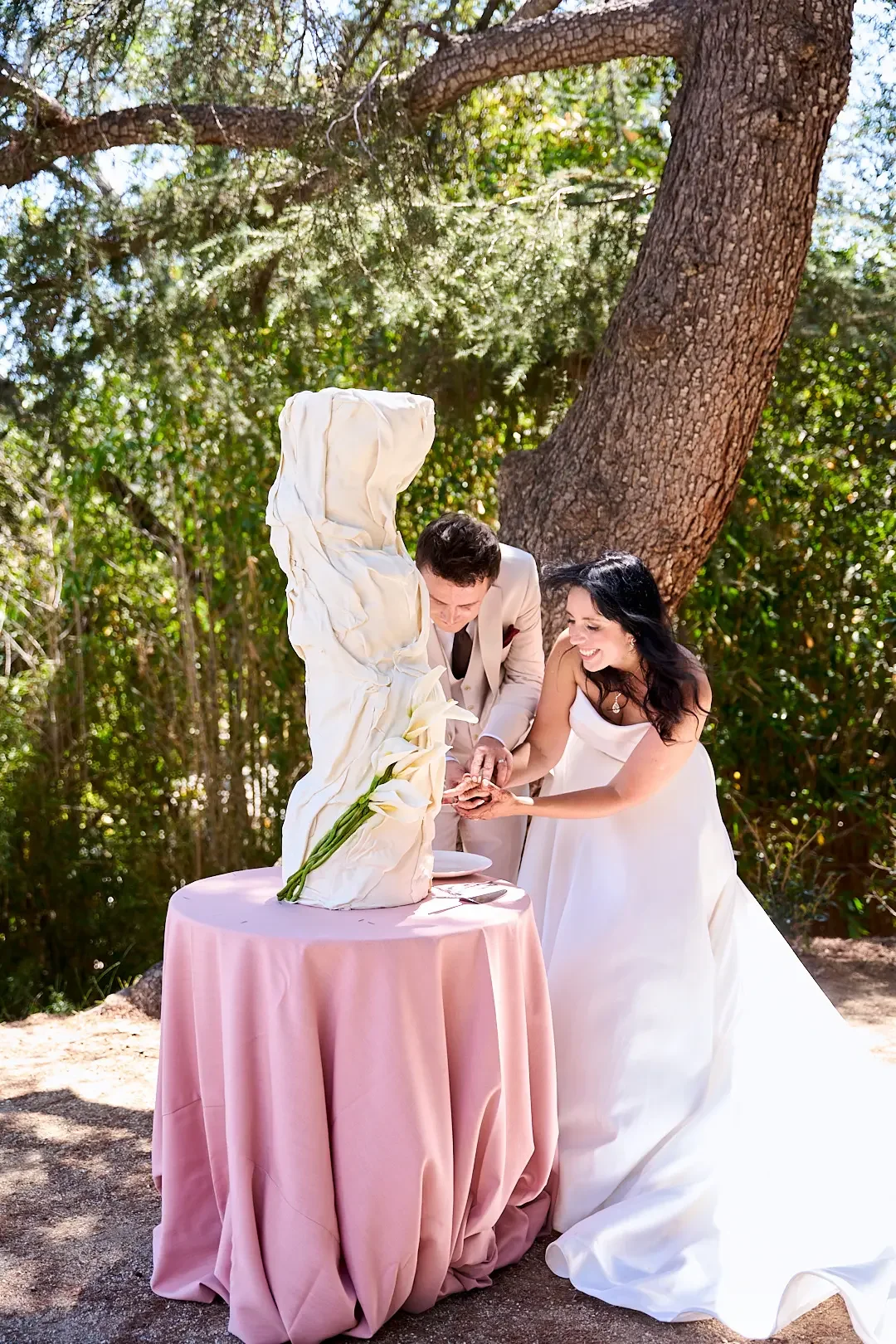 Bride and groom cutting their wedding cake beneath a mature garden tree at XOHH Events in the Hollywood Hills, Los Angeles.