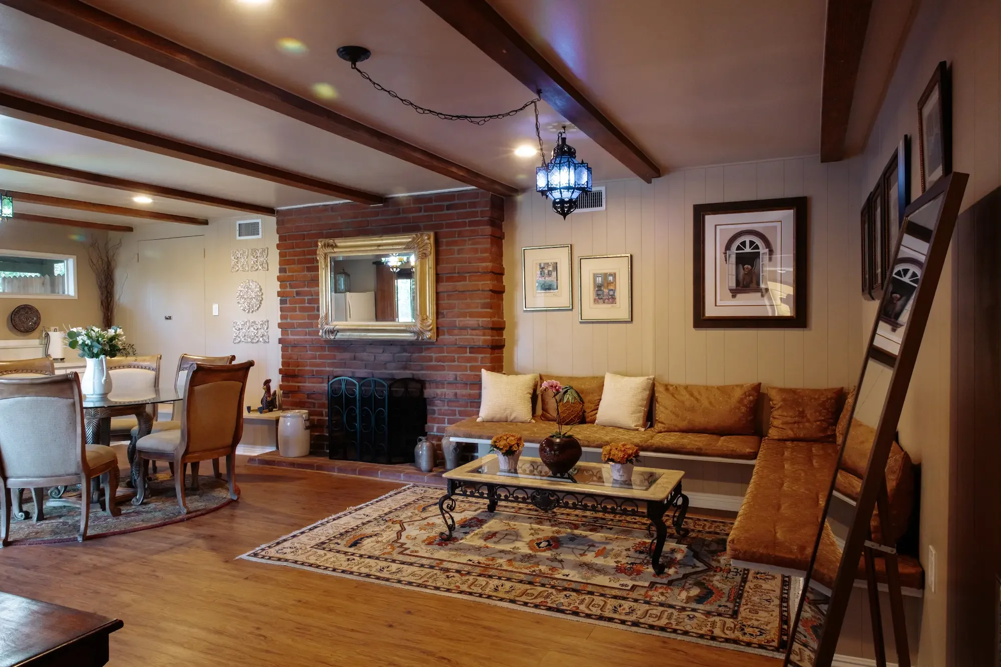 Apartment suite living area with furnishings, mirrors, fireplace, and adjacent dining space, available for makeup, wardrobe, talent holding, and other production uses. 