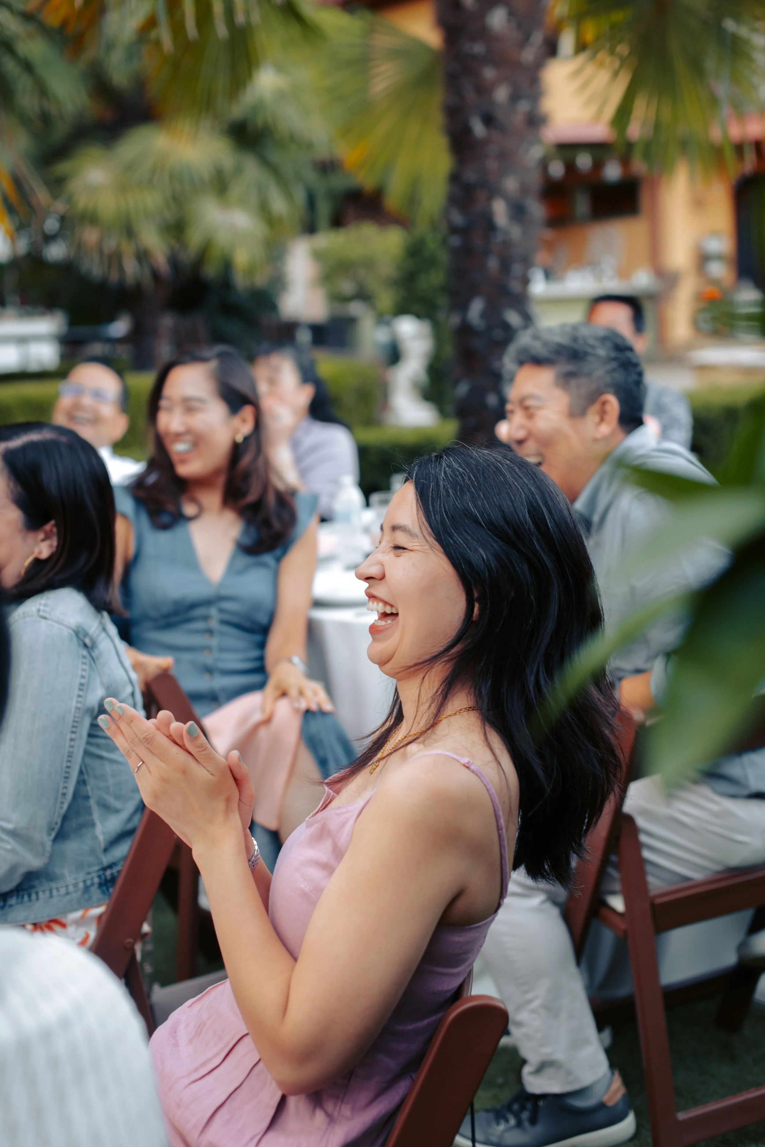 Guests laughing and applauding at an outdoor celebration