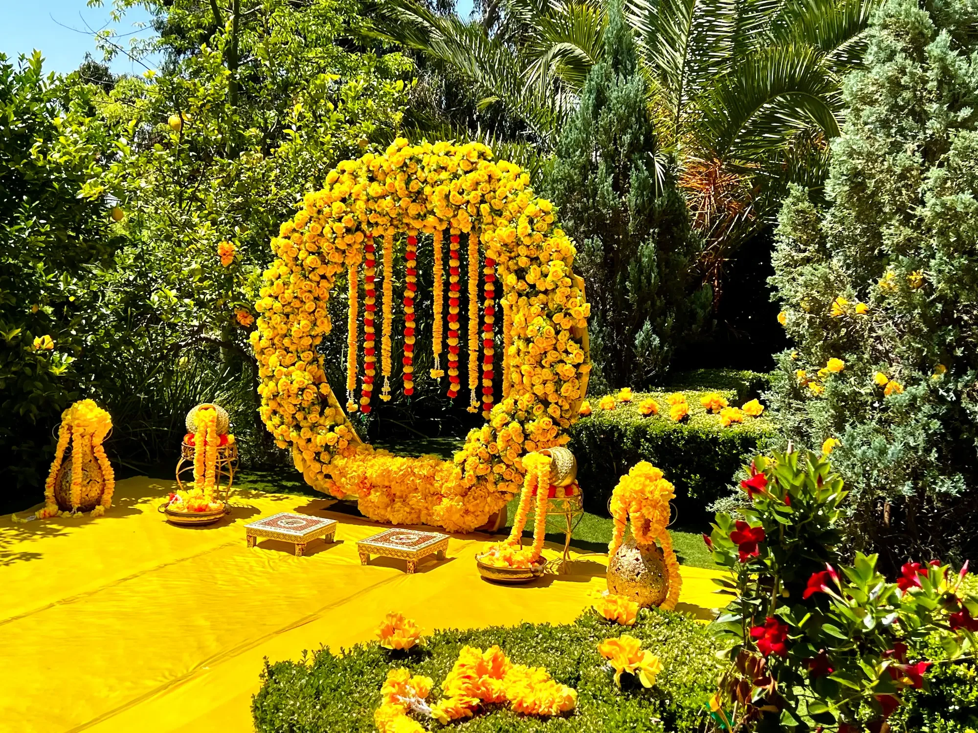 Indian wedding ceremony setup with vibrant floral décor in the garden at XOHH Events.