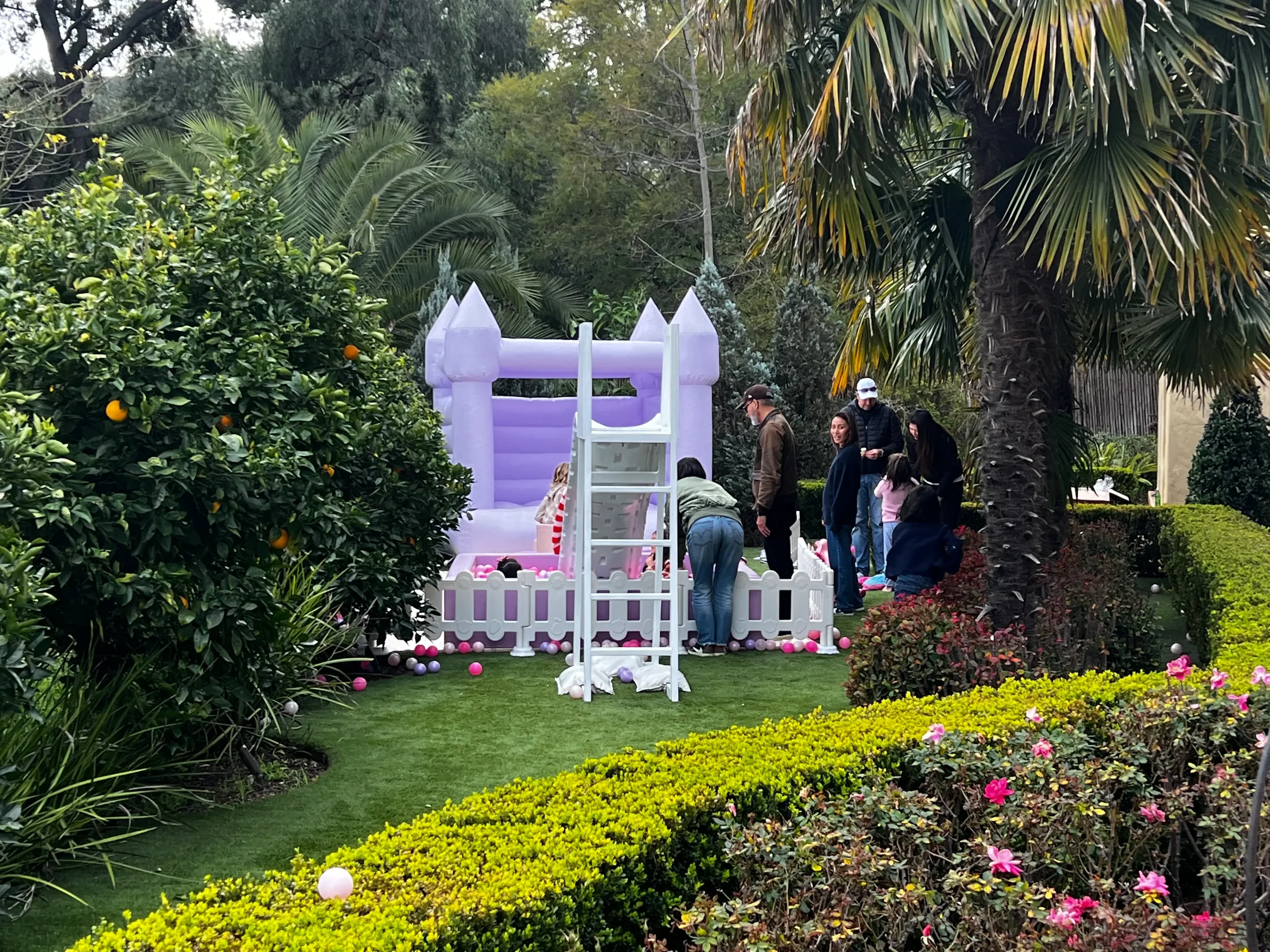 Whimsical white play structure on the lawn for a children's birthday party