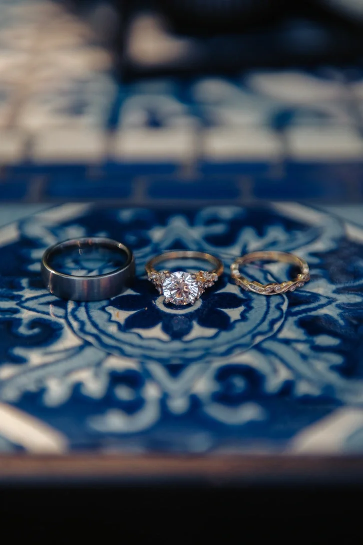 Wedding rings resting on ornate blue-and-white Moroccan tile
