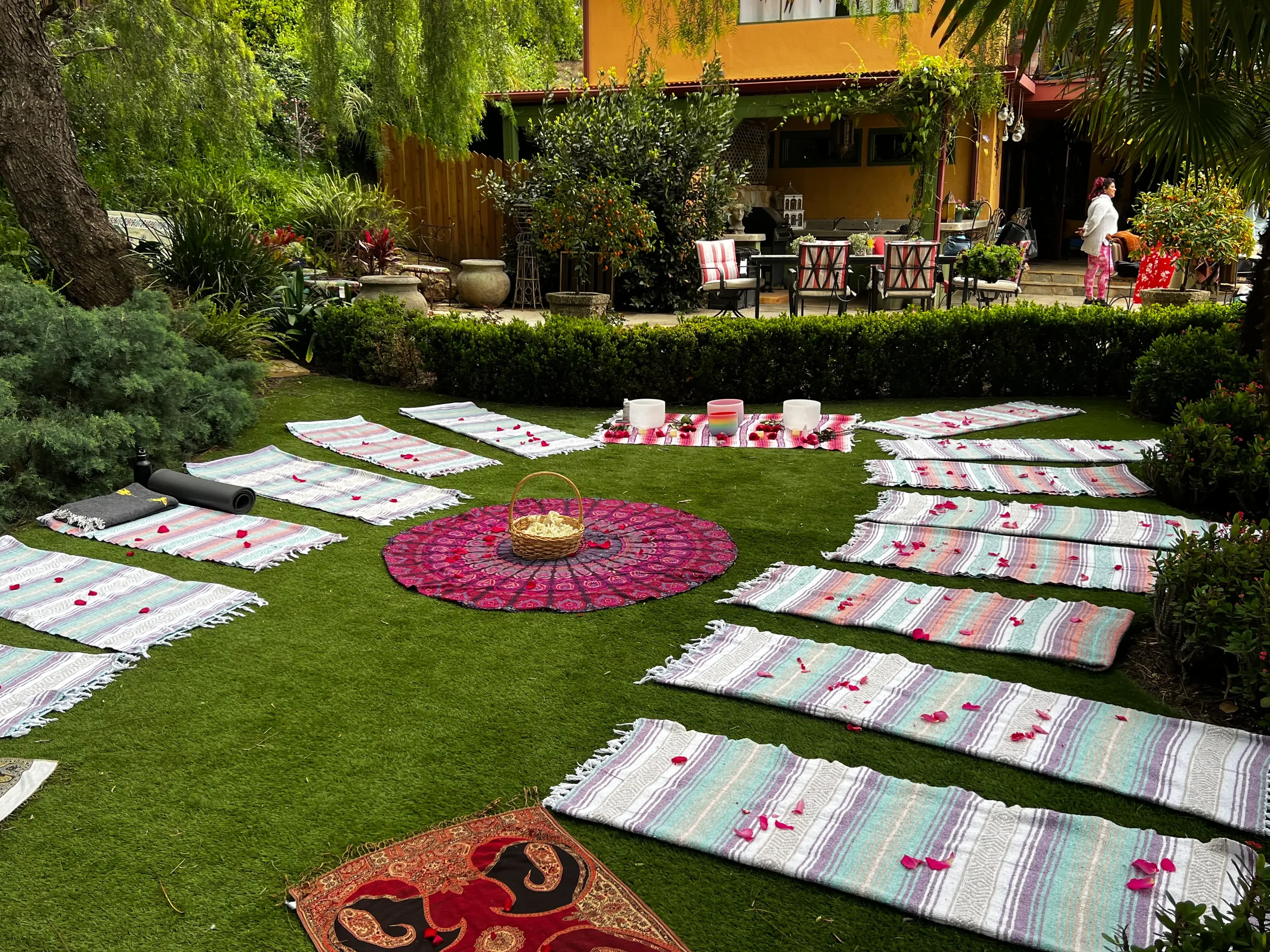 Lush lawn arranged with colorful mats around a mandala for a wellness retreat