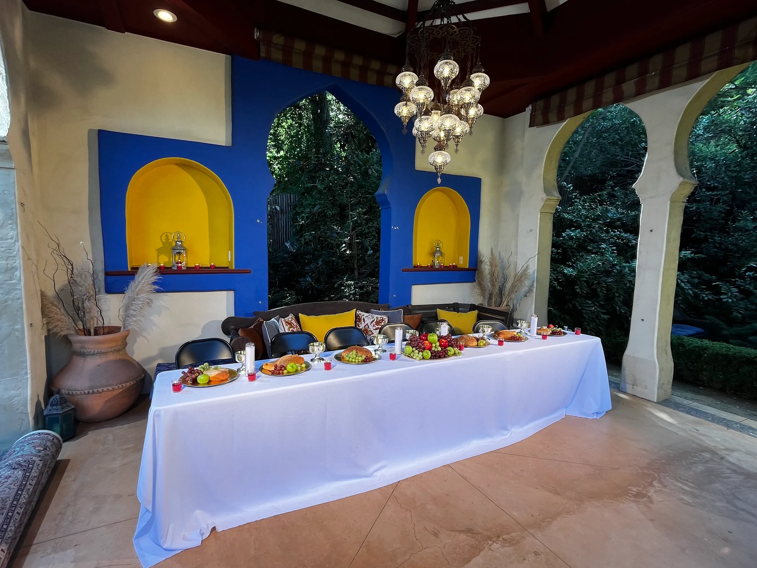 Blue Moroccan interior room with an ornate chandelier and topiary