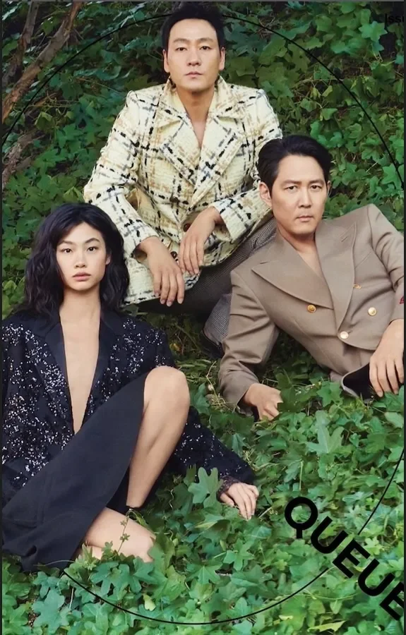 Cast in patterned suits and sequins posing among the greenery