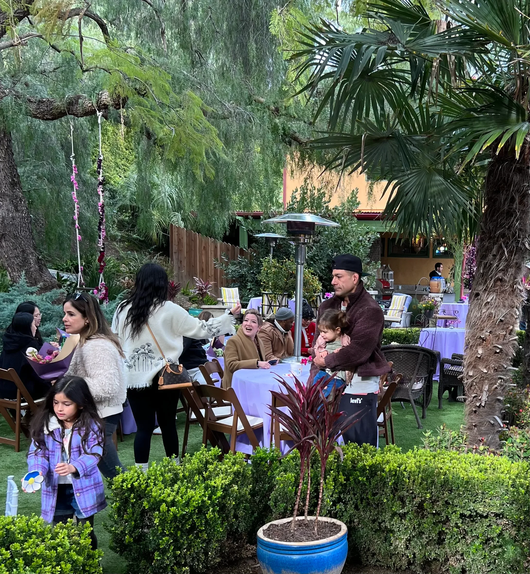 Outdoor lounge with illuminated "GLAM" letters and orange-and-blue cocktail tables