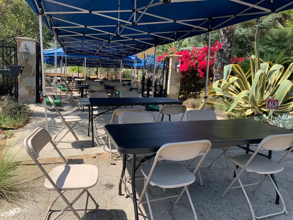 Tables and folding chairs beneath a canopy for outdoor crew holding at XOHH Events, a private Hollywood Hills production location.
