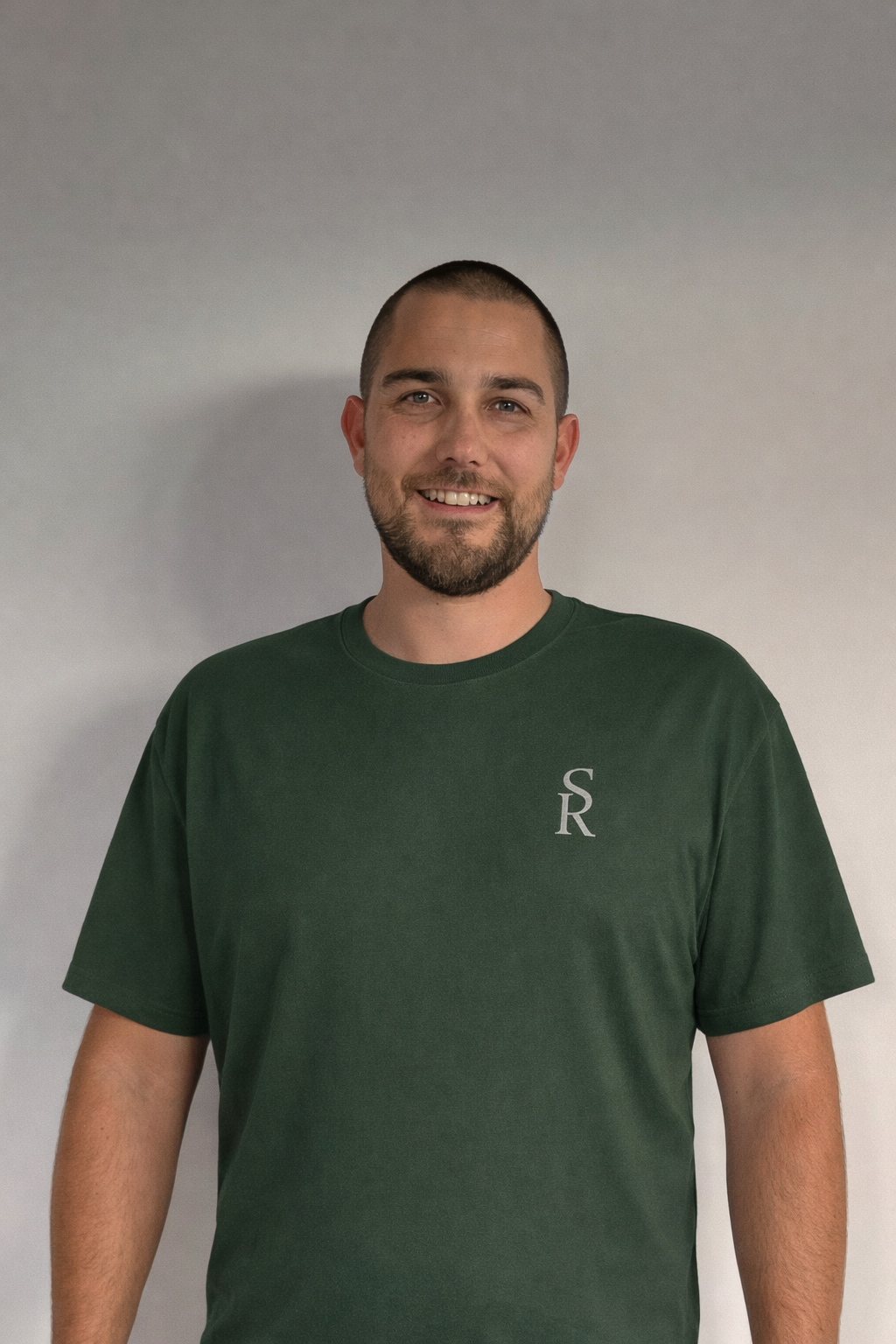 Kale, microcement applicator at Surface Revival, wearing branded SR shirt against a neutral background