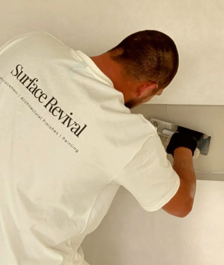Kale from Surface Revival hand-applying a decorative finish around a recessed wall niche.