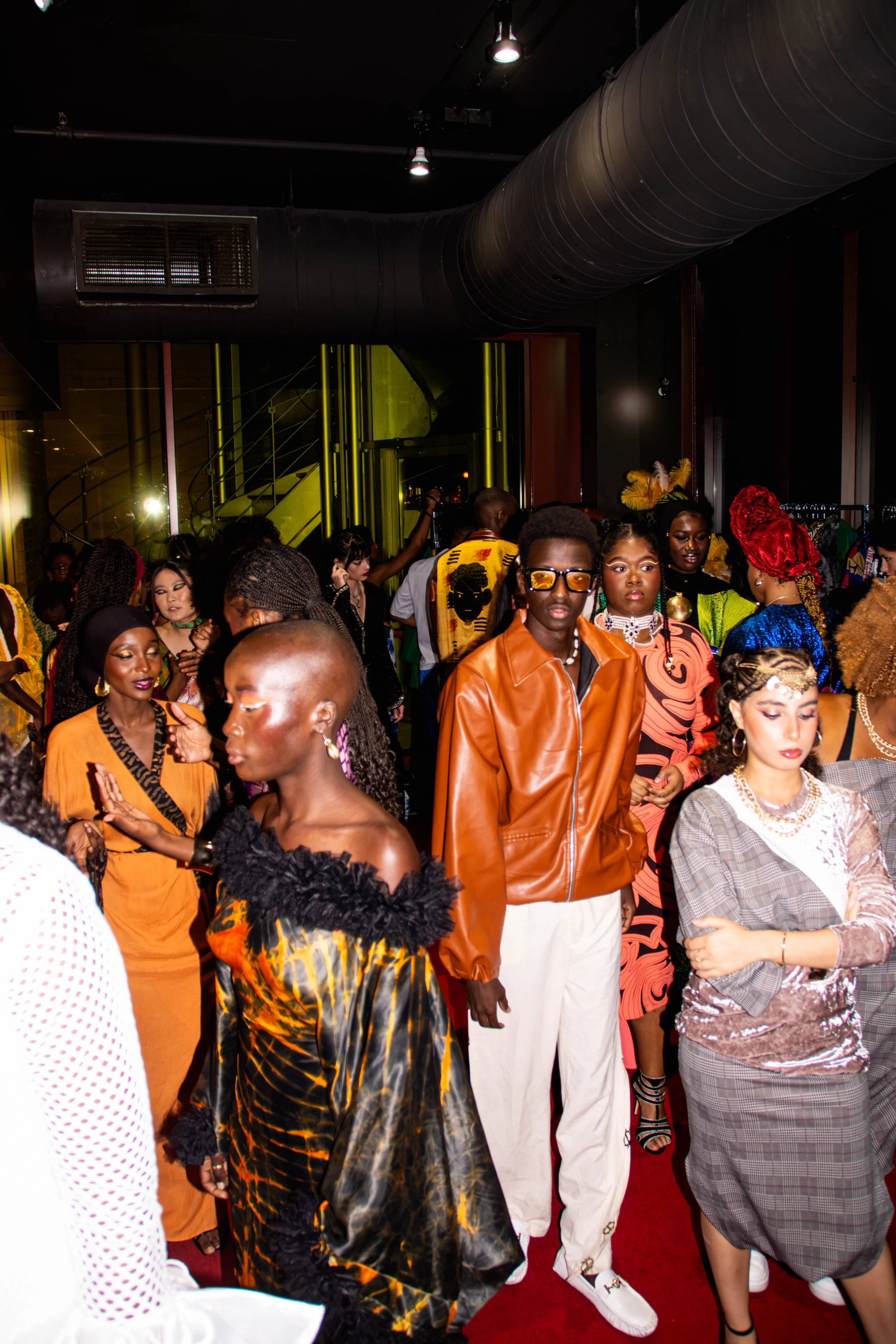 Un groupe de personnes de mode africaine lors d'un événement avec des vêtements colorés et variés, ambiance festive et élégante.