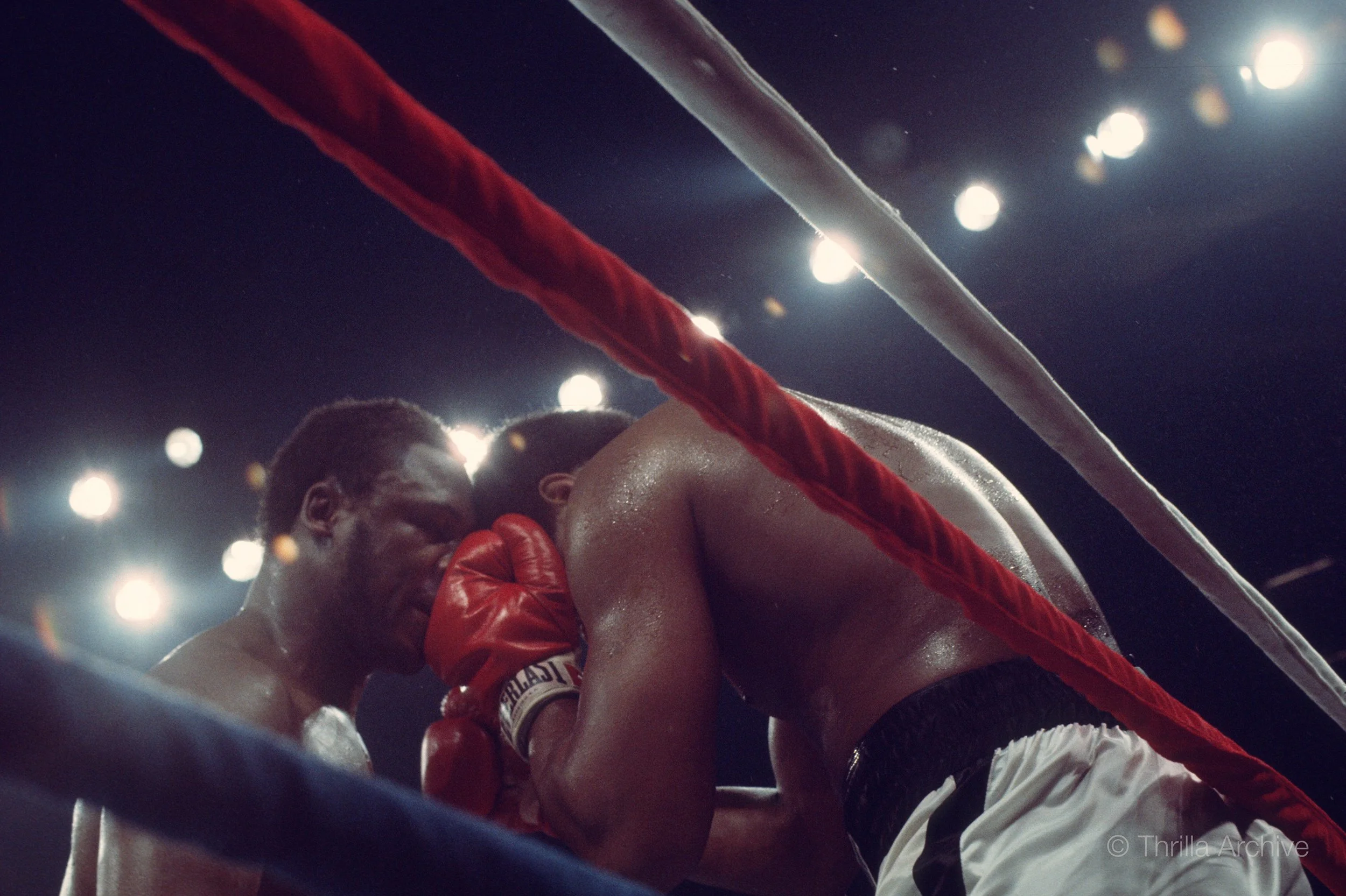 Claustrophobic inevitability and visible exhaustion as Joe Frazier exerts pressure in the corner against Muhammad Ali in the historic Thrilla in Manila, October 1, 1975, photographed by Lowell K. Riley