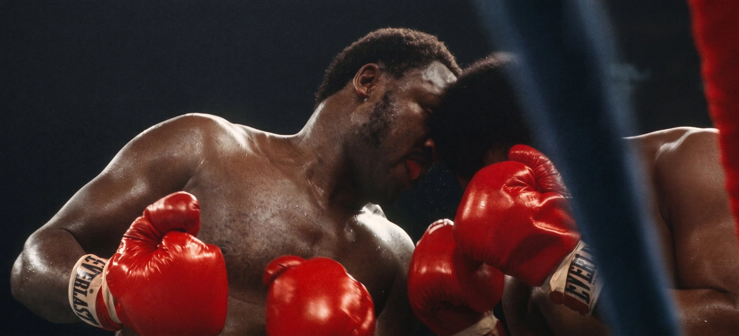 Joe Frazier leans into Muhammad Ali at close range, their heads, shoulders, and gloves pressed together during the Thrilla in Manila.