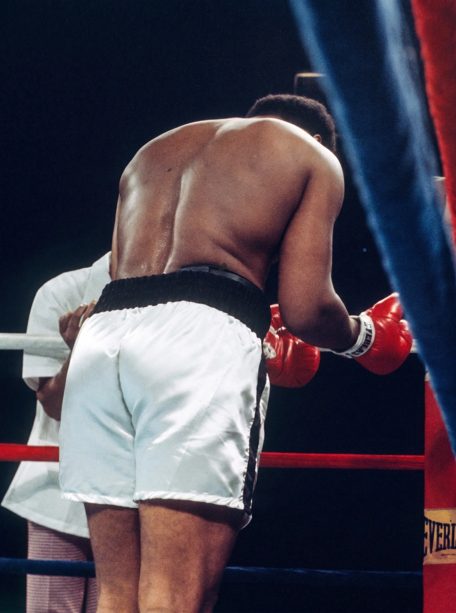 Muhammad Ali bows his head and extends his gloved hands in prayer in his corner before the opening bell of Ali-Frazier III.