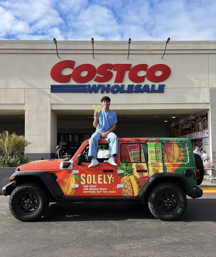 Ambassador sitting on a Solely-wrapped jeep outside Costco Wholesale