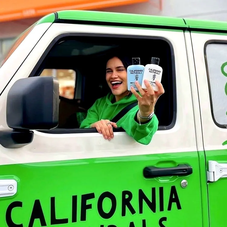 Ambassador in a green California Naturals-wrapped vehicle outside an Ulta store