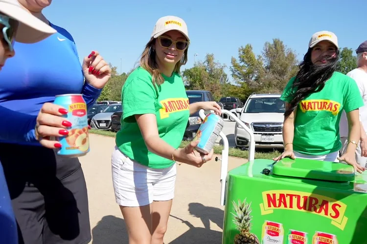 Natura's brand ambassadors sampling cans beside a Natura's cart