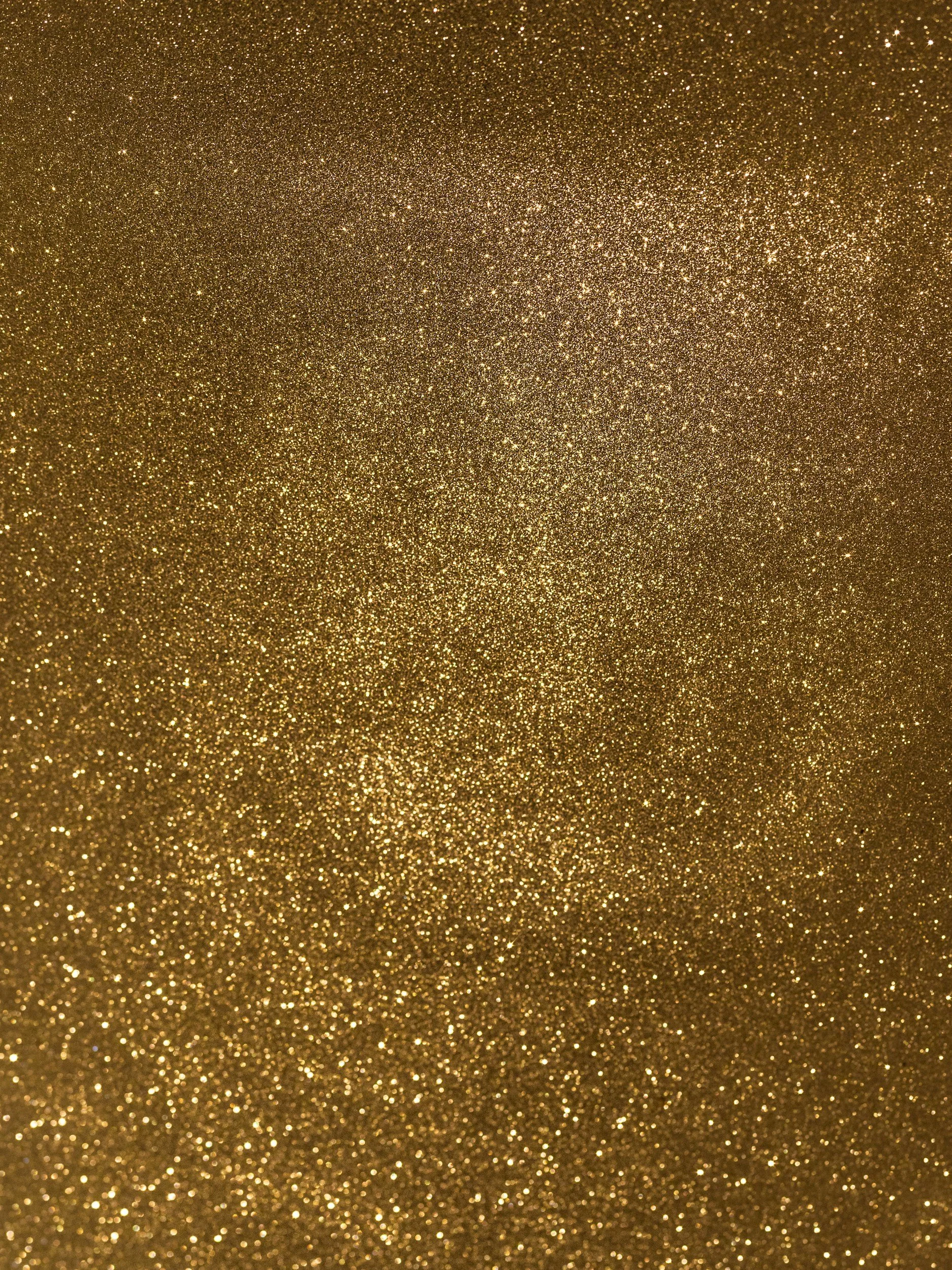 Close-up of gold glitter surface with sparkly texture.