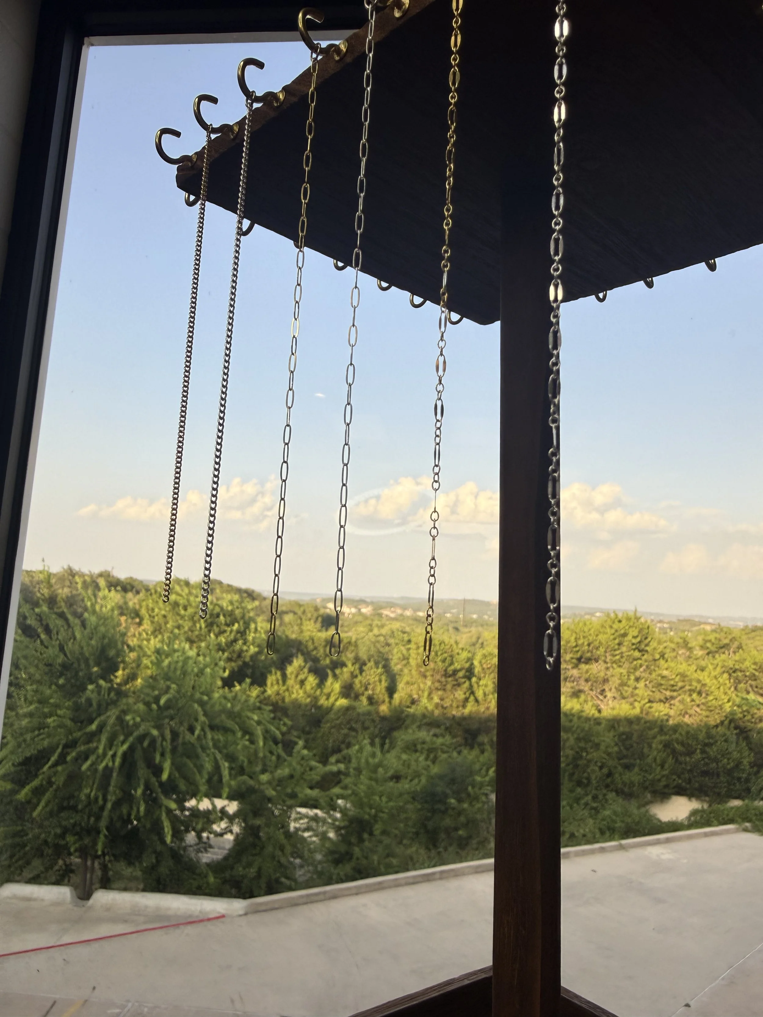 Permanent jewelry chains hanging outside with a Hill Country view, Lago Vista TX