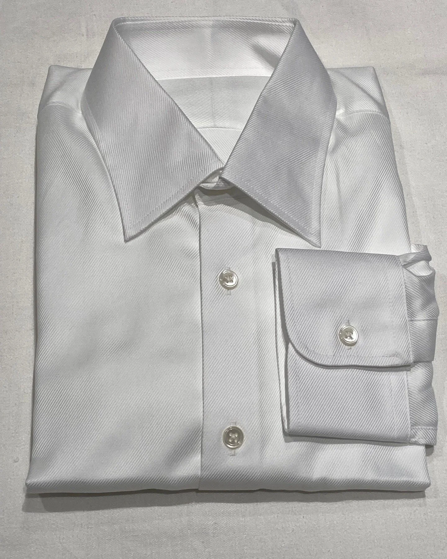 A twill shirt that can be worn to the office, with or without a tie, on formal and informal occasions. This men's twill shirt has a subtle but distinct twill texture. Mother of pearl buttons and round barrel cuffs complete an elegant look.

#twillshi