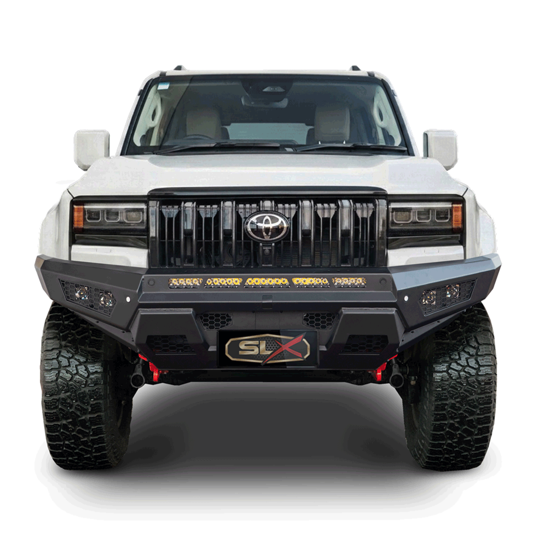 Front view of a white off-road pickup truck with a black grille, black bumper with LED lights, large tires, and a black license plate with 'SLX' logo.