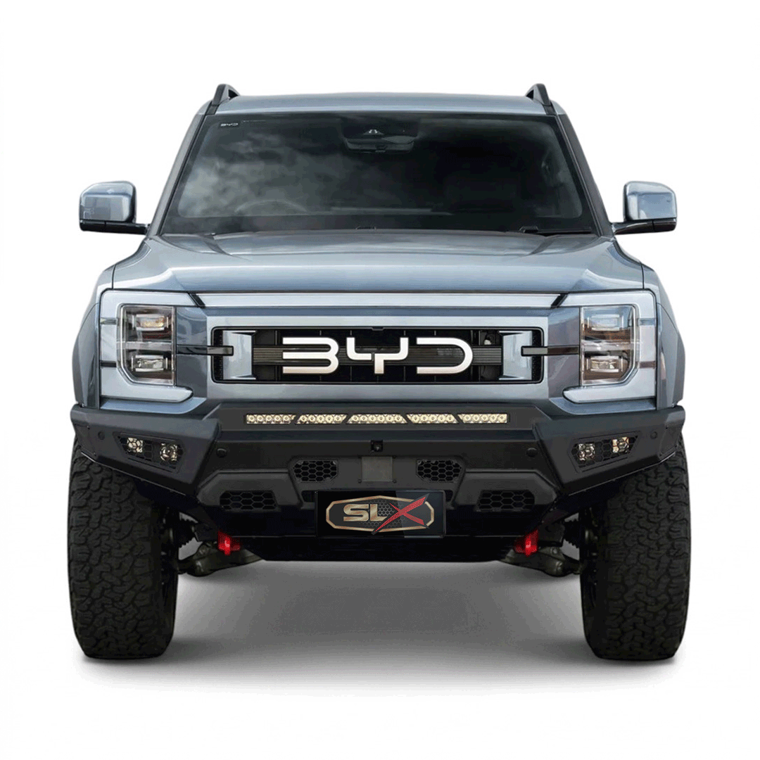 Front view of a silver off-road pickup truck with black grille and large tires, displaying the BYD logo and SLX branding.