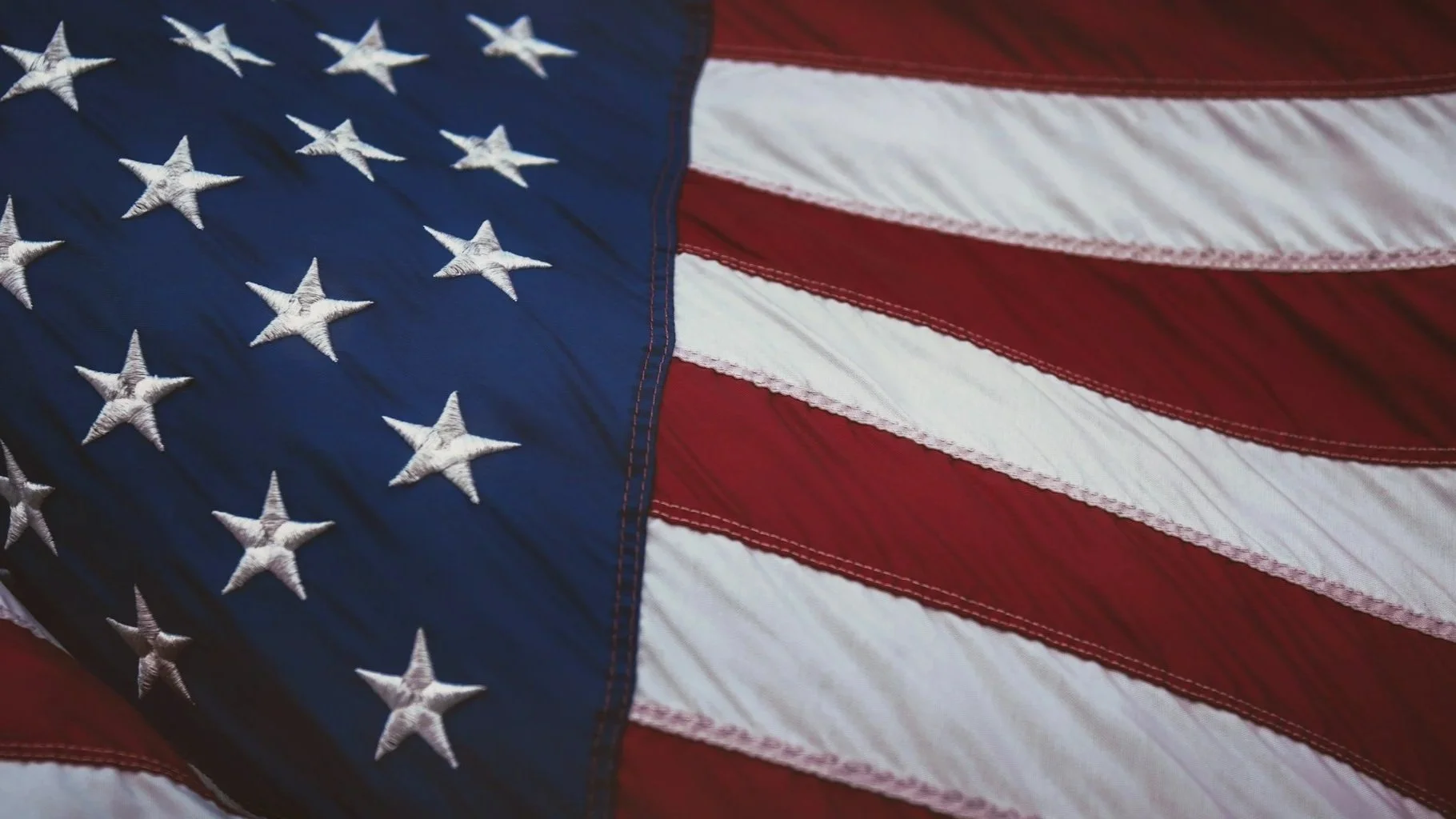 A close-up of the American flag with red and white stripes and white stars on a blue field.