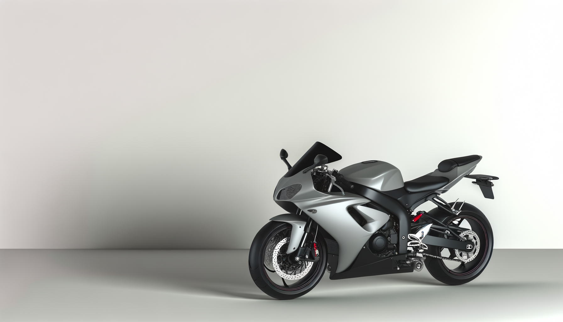 Silver and black sports motorcycle parked against a plain wall