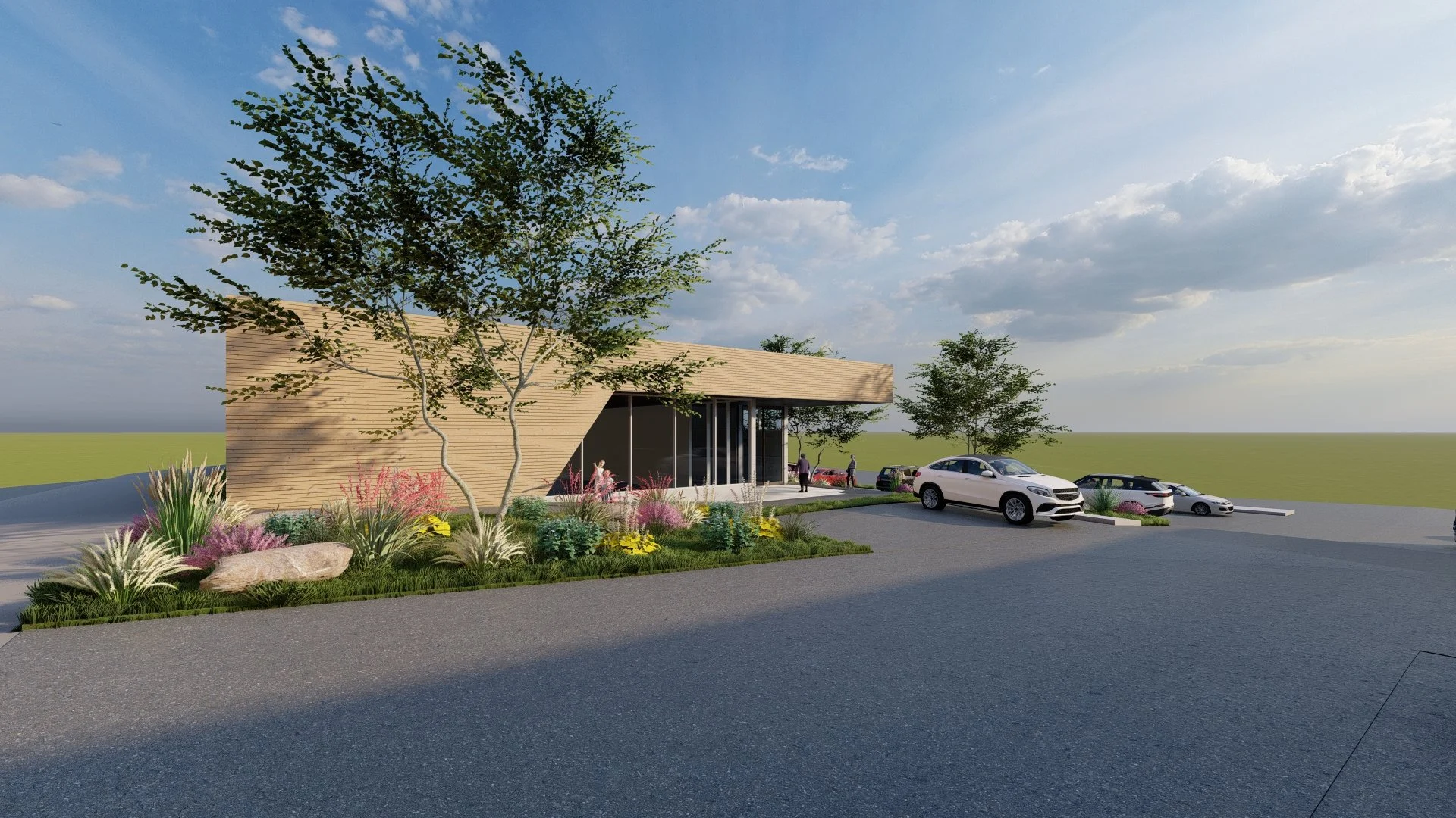 Modern building with wooden exterior, landscaped greenery with flowers and trees, and a parking lot with several cars and people walking.