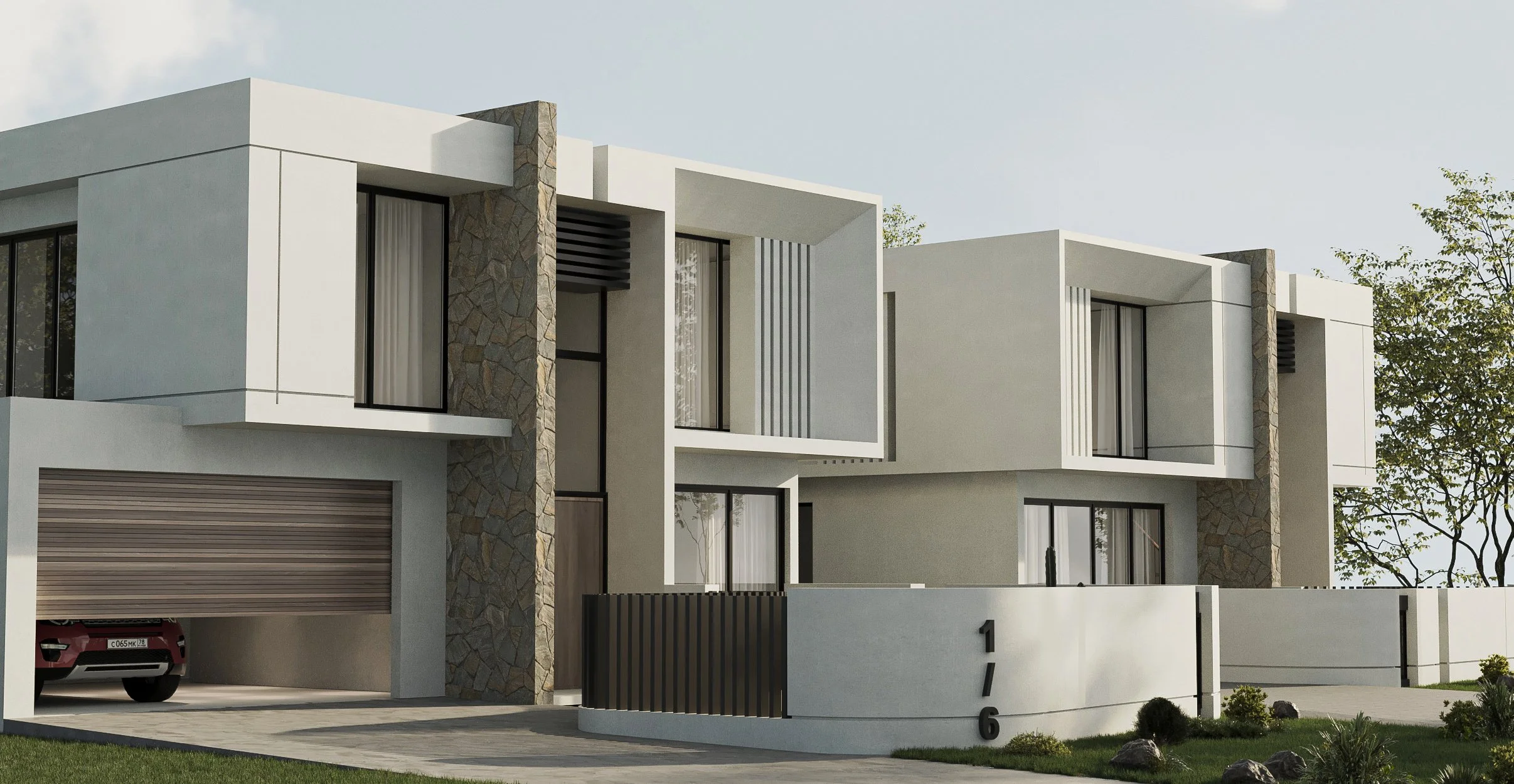 Modern white residential building with stone accents, large windows, and a driveway with a red car parked inside, surrounded by a landscaped yard with grass and small plants.