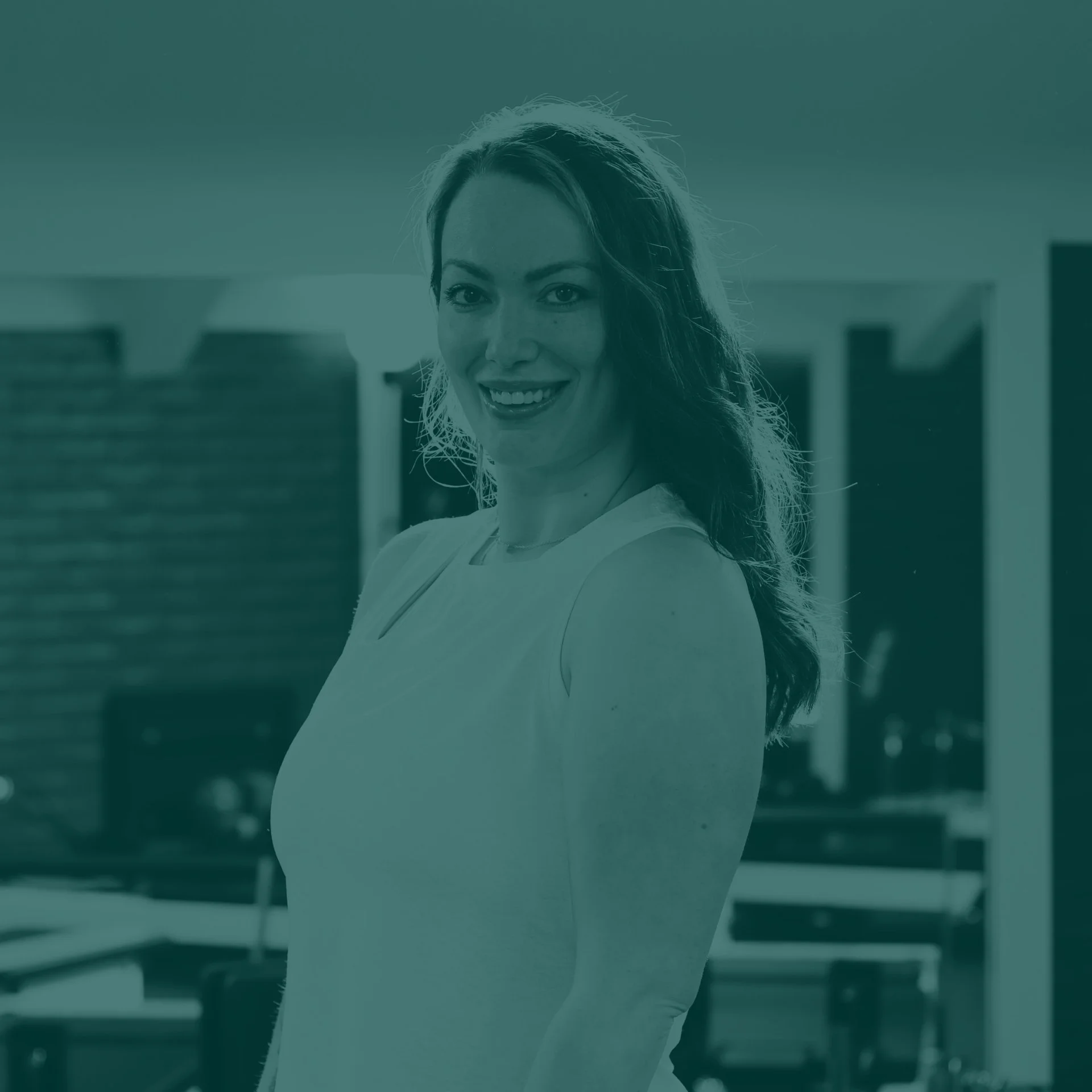 A woman smiling with a modern kitchen background.