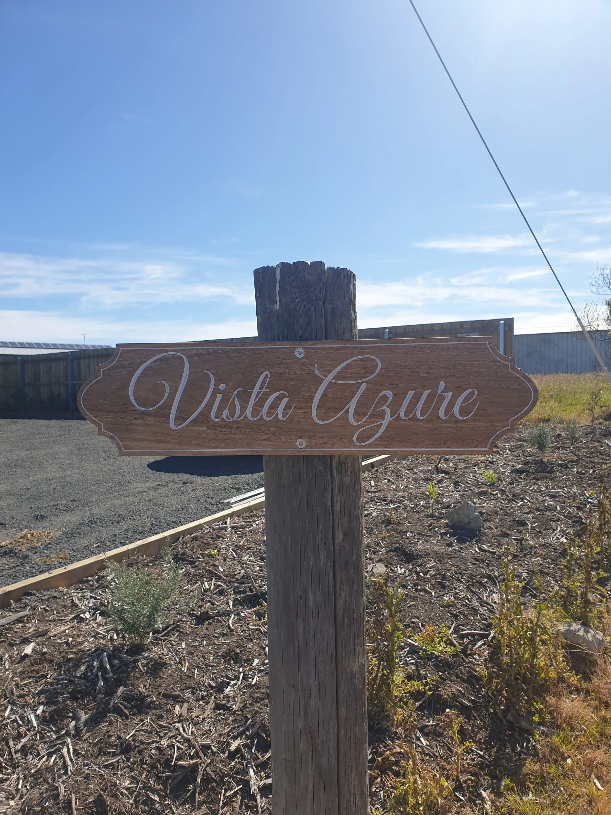 A picture of the wooden sign outside the property titled 'Vista Azure'.