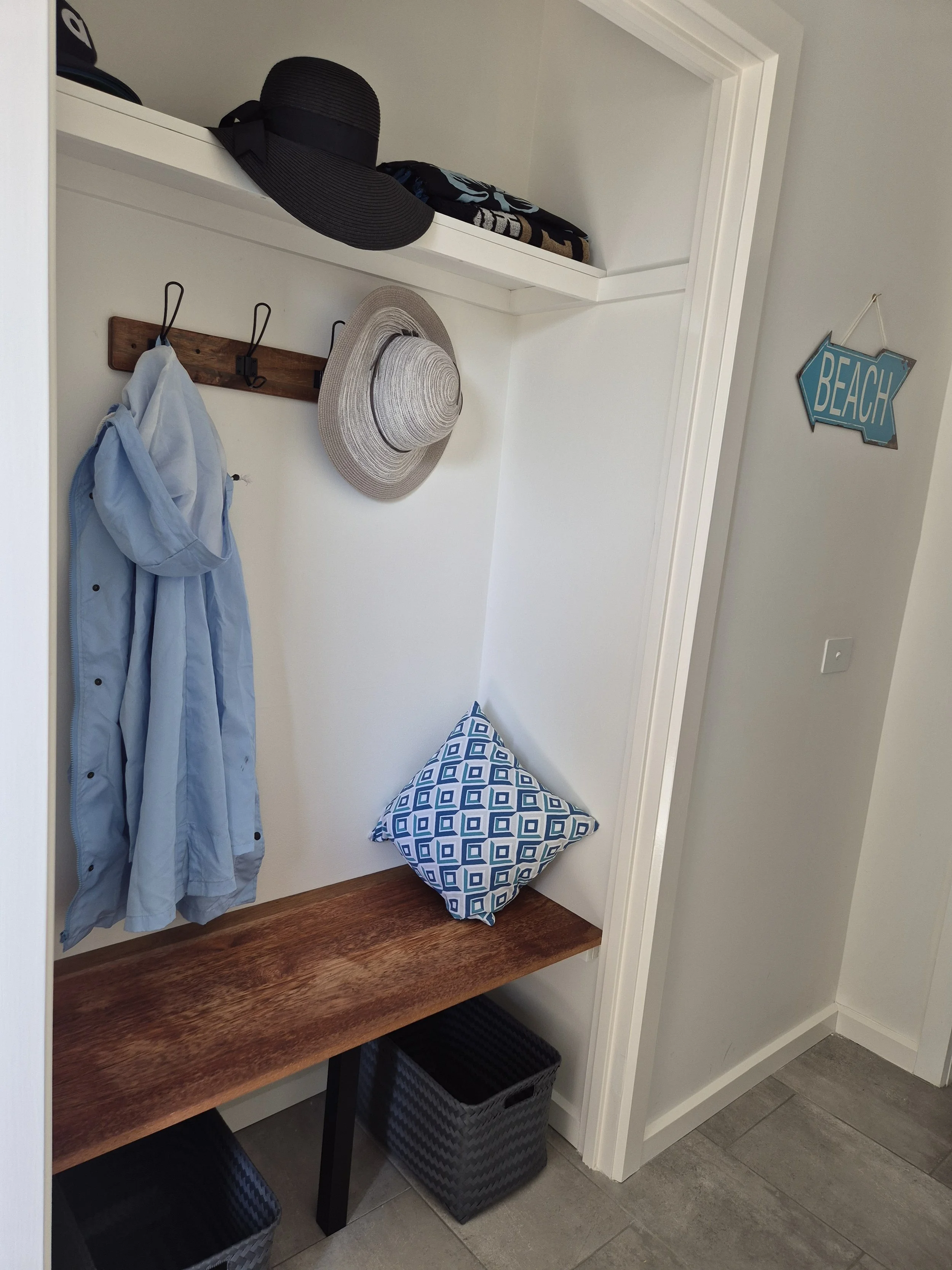 A picture of the bench seat and jacket hanging space in the ground floor of the house.