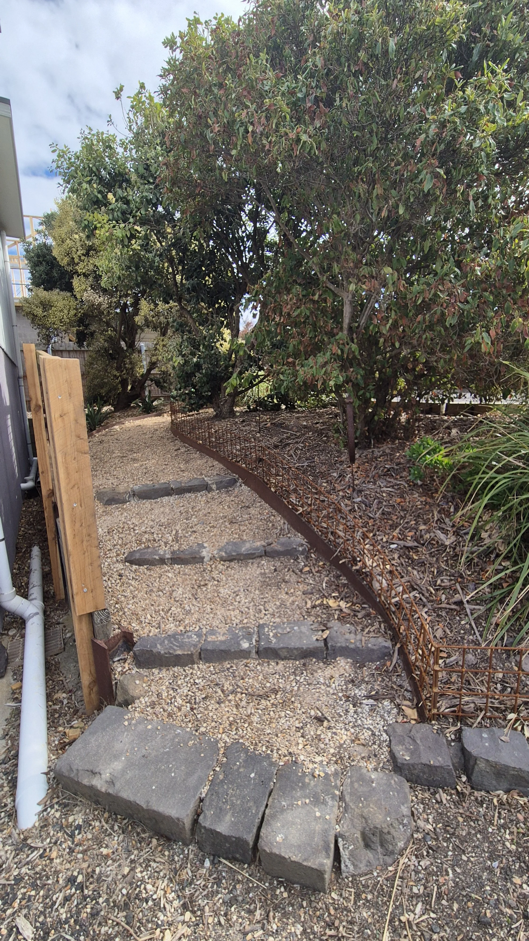 A stone pathway with steps leading up the side of the house. 